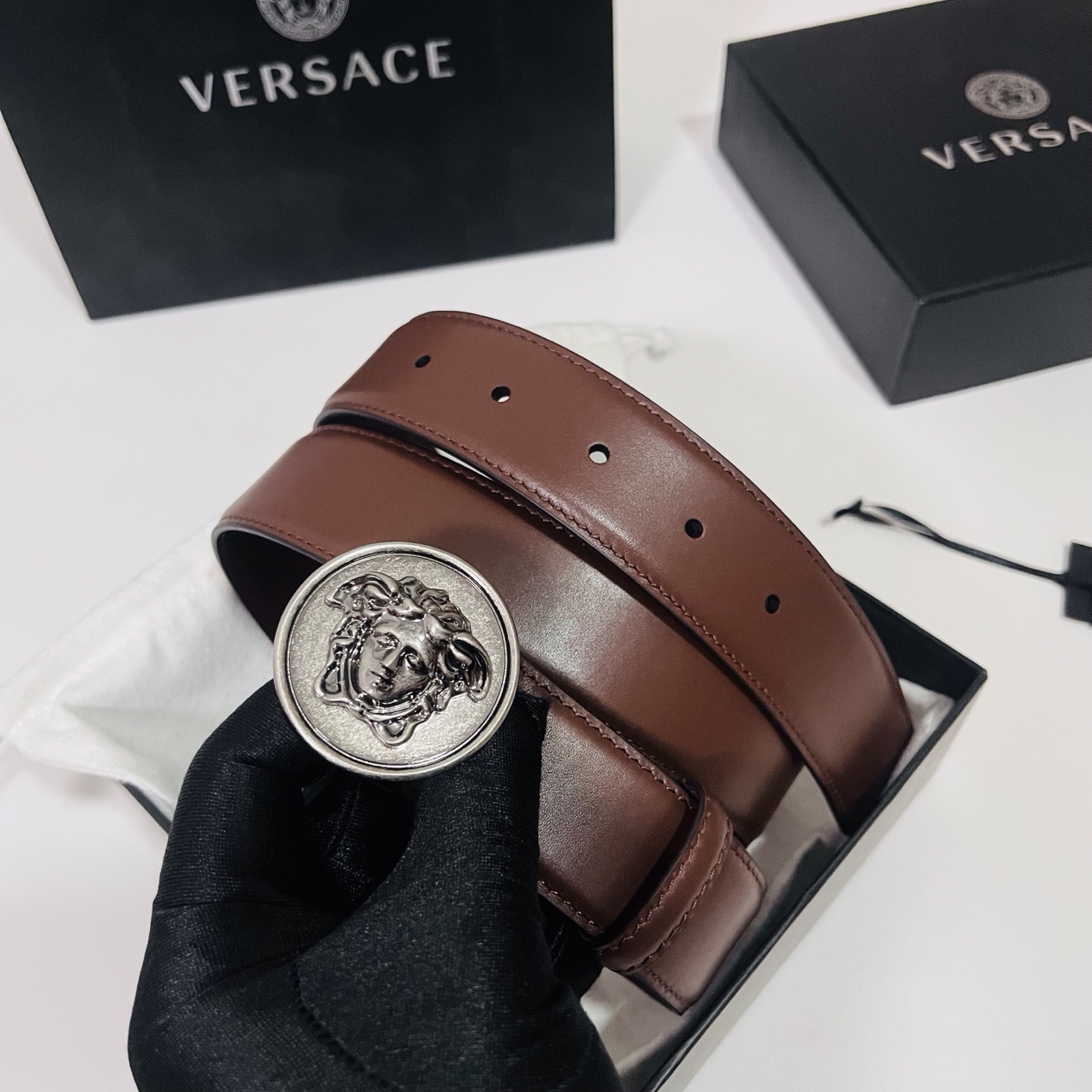 范思哲，新款牛皮革腰带，饰有Versace Logo字样，配有圆形金属搭扣，搭扣采用复古饰面，镶嵌立体M