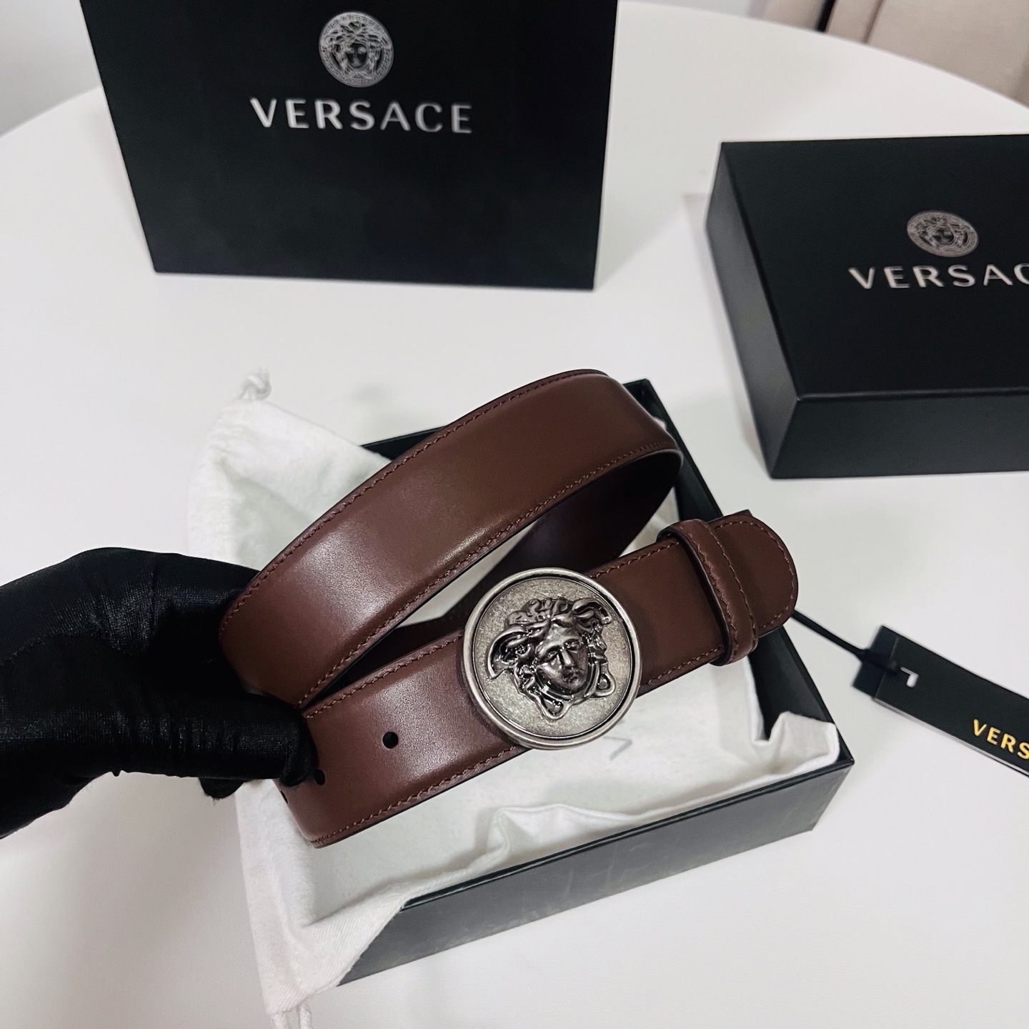 范思哲，新款牛皮革腰带，饰有Versace Logo字样，配有圆形金属搭扣，搭扣采用复古饰面，镶嵌立体M