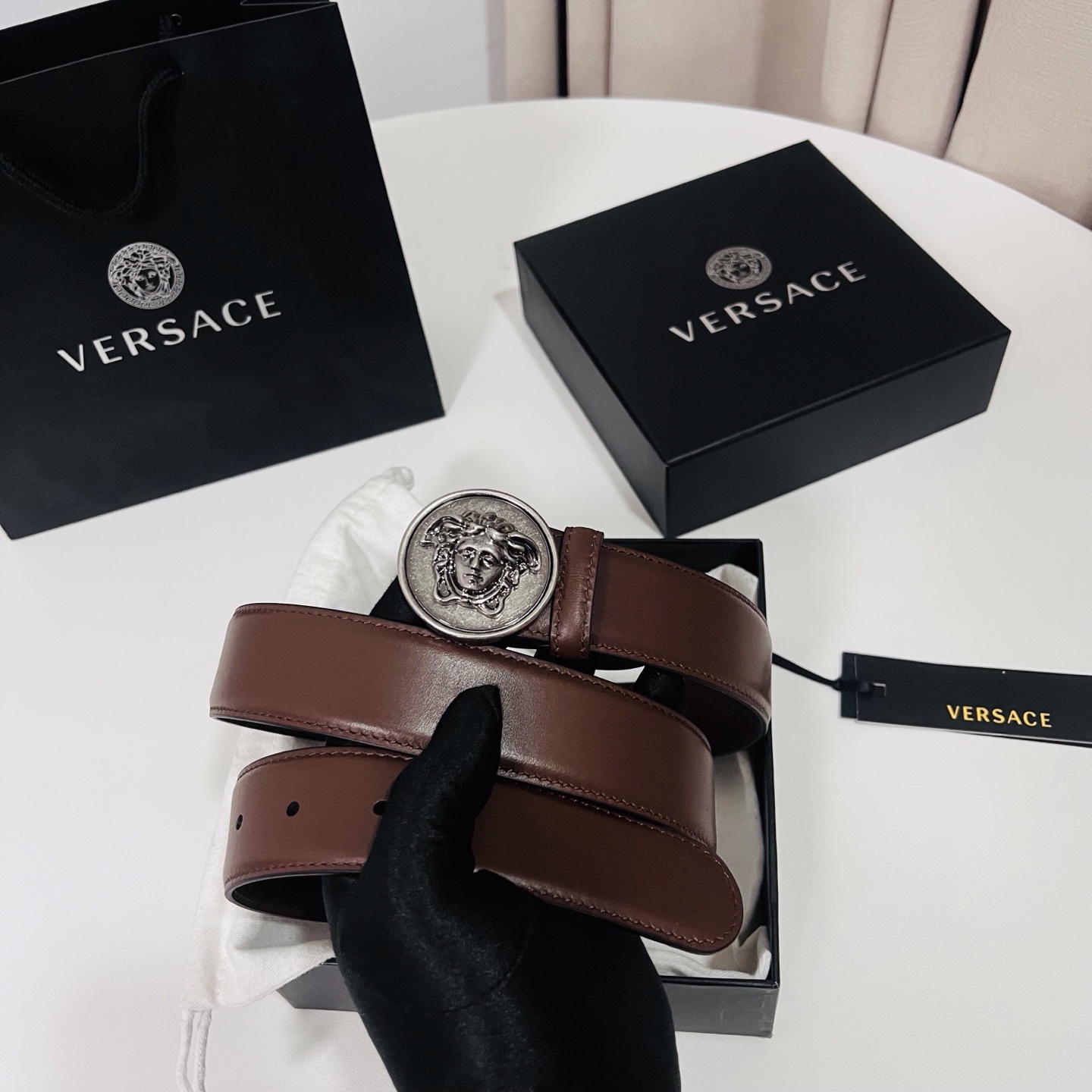 范思哲，新款牛皮革腰带，饰有Versace Logo字样，配有圆形金属搭扣，搭扣采用复古饰面，镶嵌立体M