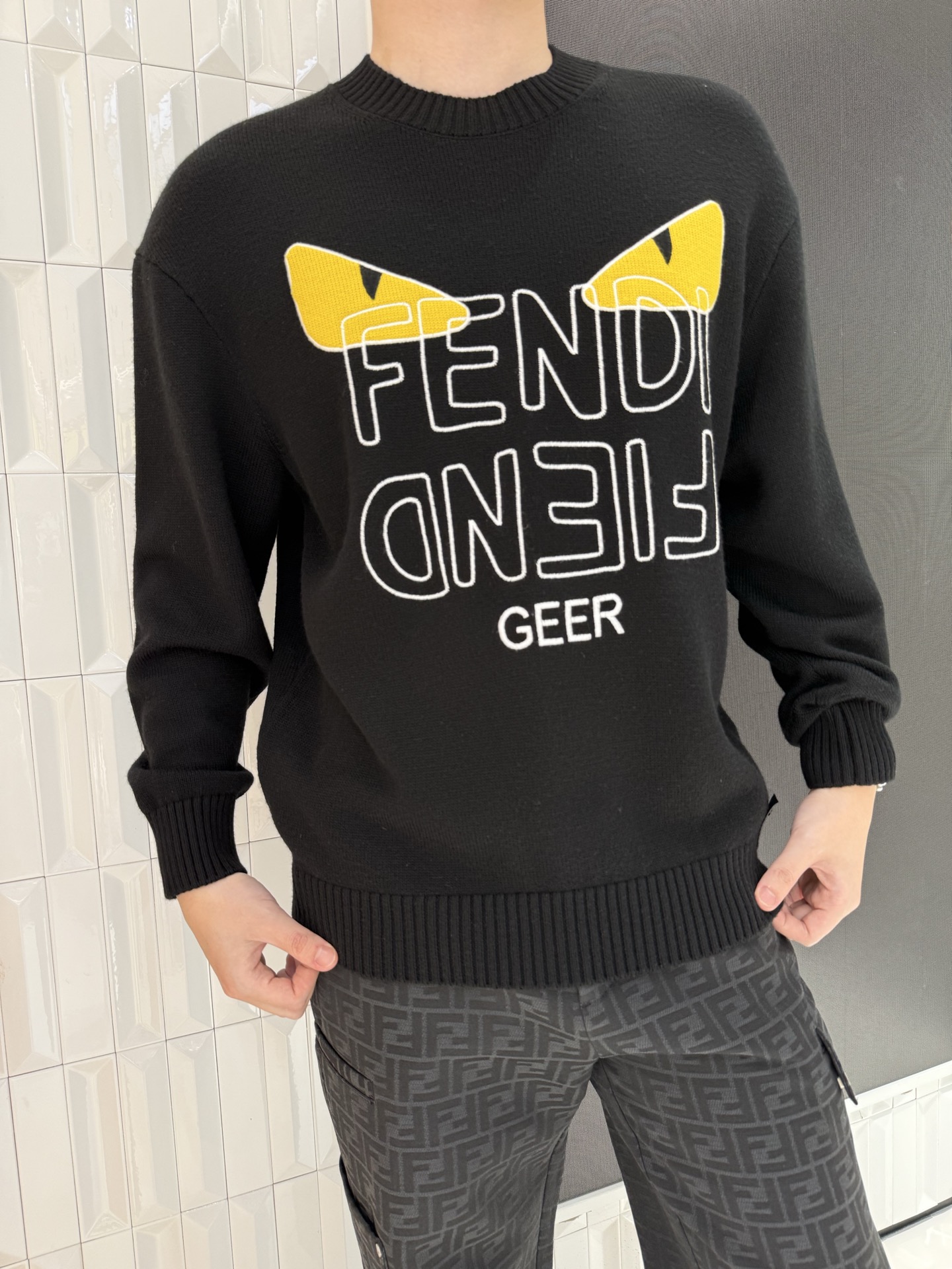 NO:728620,FENDI autumn and winter woolen sweaters, end-of-the-counter quality 1. Interesting pattern design, eye-catching personality, classic little monster eye print with letter line design, contrasting yellow and black colors, strong visual impact, breaking the monotony of solid color sweaters, full of street fashion, niche style. 2. Soft and waxy knitted fabric, skin-friendly and warm  Selected fine knitted yarn, soft and waxy to the touch without scratching the skin, good warmth retention, suitable for wearing alone or layered in autumn and winter, and you will not feel tight and uncomfortable after sitting for a long time. 3. Loose shoulder design, not picky about the figure. The loose cut of the shoulder accommodates various body shapes, corrects problems such as shoulder width and thick arms, creating a lazy and relaxed wearing atmosphere, which can be worn by boys and girls. 4. Basic round neck design, versatile and practical.  The classic round neck is suitable for various combinations. It can be worn with jeans, overalls, and casual pants. It can be worn in daily outings, dates, commuting, etc. Sizes 48-56 (model is 180cm tall and weighs 140cm, wearing size 50), fendi, jeans, sweaters,19860909FENDI秋冬羊毛衣,专柜尾货品质 1. 趣味图案设计,个性吸睛 经典小怪兽眼睛印花搭配字母线条设计,撞色黄黑视觉冲击力强,打破纯色毛衣的单调,街头潮感拉满,小众不撞款. 2. 软糯针织面料,亲肤保暖 精选细腻针织纱线,触感软糯不扎肤,保暖性佳,秋冬单穿或内搭都合适,久坐也不会有紧绷不适感. 3. 宽松落肩版型,不挑身材 落肩宽松剪裁包容各种身形,修饰肩宽、手臂粗等问题,打造慵懒松弛的穿搭氛围,男生女生都能穿. 4. 基础圆领设计,百搭实穿 经典圆领适配各种搭配,可搭牛仔裤、工装裤、休闲裤,日常出街、约会、通勤等场景都能hold住. 48-56码（模特身高180体重140穿50码）,,fendi,jeans,sweaters,,Men's clothing