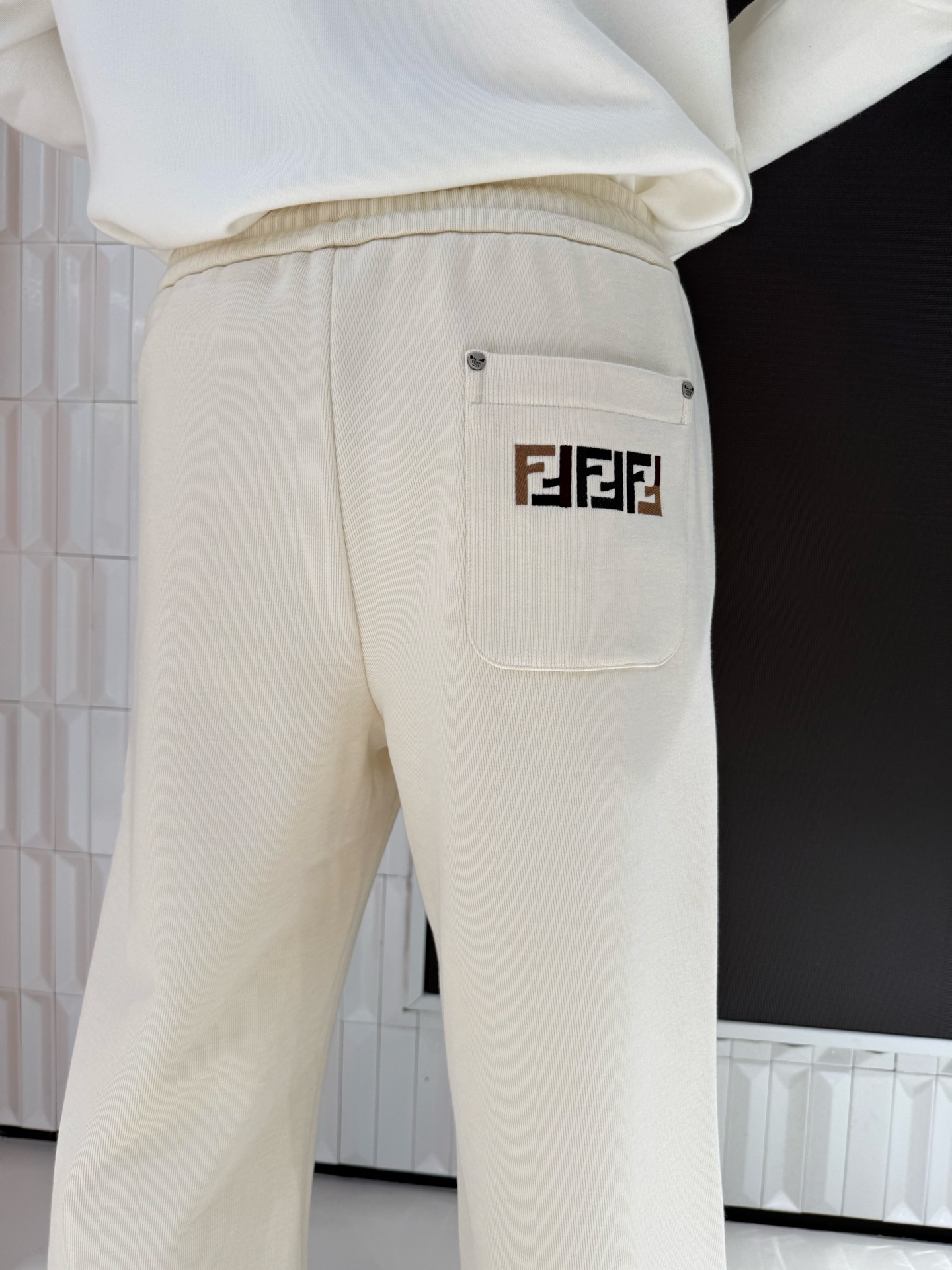 NO:691224,FENDI autumn and winter trousers, exclusive counter quality. These casual trousers are mainly off-white, visually very recognizable, and can easily create a sense of street fashion. They are made of high-elastic and skin-friendly cotton fabrics, which are soft and breathable, and will not be stuffy after long-term wear. The loose straight fit is friendly to all body types, and can modify the shape of the legs while allowing unrestricted movement. The drawstring waist design can be freely adjusted for tightness, and the brand logo embroidery in the details adds texture. Whether it is daily commuting or casual outings, it is a versatile and eye-catching choice.  29-58 yards,,fendi,19860909FENDI秋冬长裤,专柜尾货品质 这款休闲裤以米白色为主调,视觉上极具辨识度,轻松打造街头潮流感.采用高弹亲肤的棉质面料,柔软透气,久穿不闷；宽松直筒版型对各种身材都很友好,修饰腿型的同时活动无束缚.抽绳腰头设计可自由调节松紧,细节处的品牌标识刺绣更添质感,不管是日常通勤还是休闲出街,都是百搭又吸睛的选择. 29-58码,,fendi,,Men's clothing
