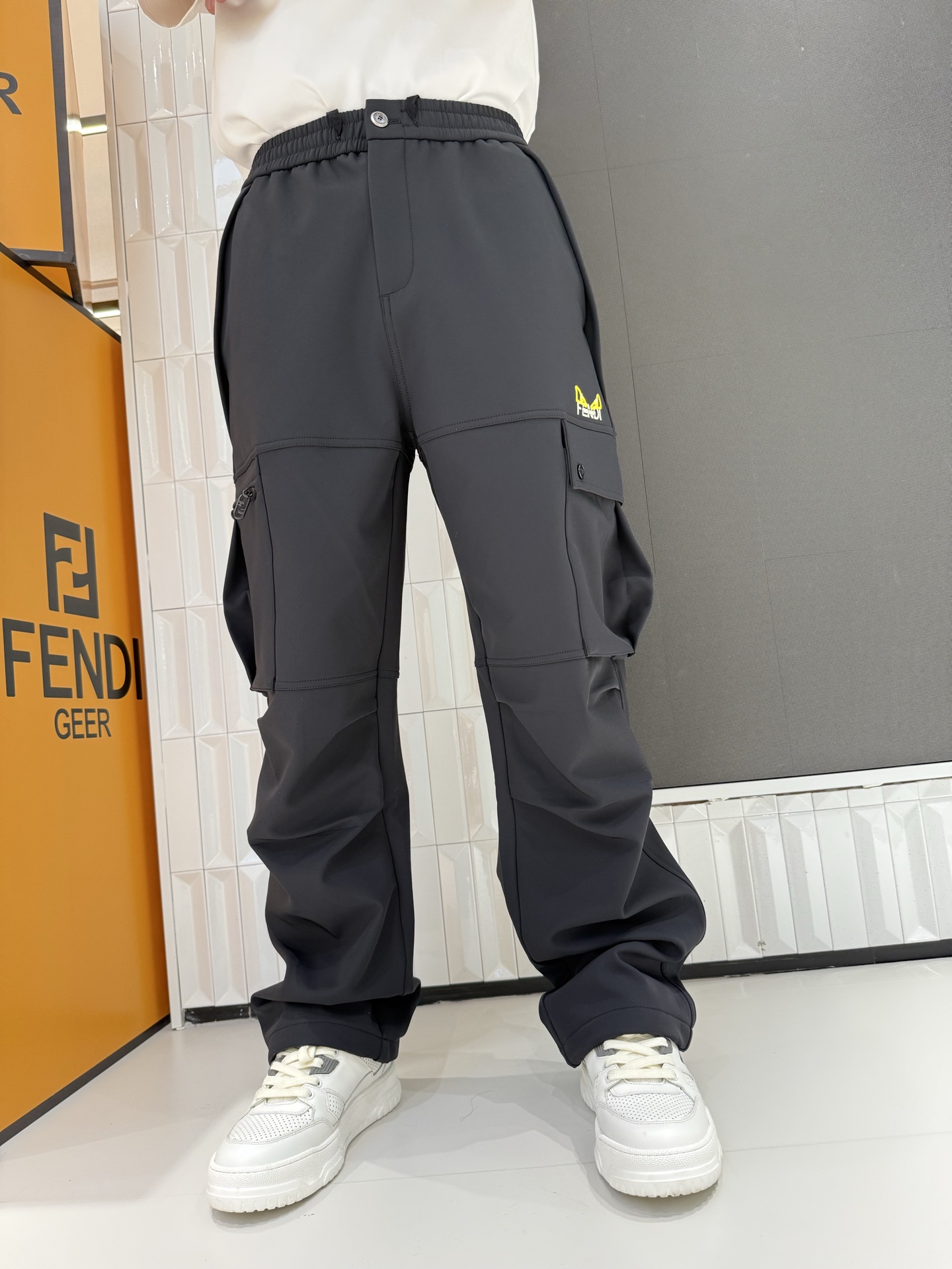 NO:691210,FENDI counter goods, a must-have for autumn and winter  These dark gray overalls are made of quick-drying ice-like fabric, which is smooth and breathable to the touch. They are refreshing and non-sticky to wear in summer. They are suitable for daily sports or travel. They are cut with three-dimensional workwear. The large pocket design is both practical and fashionable, and can easily store small items; elasticated loose  The tight waistband with button design allows the waist to be flexibly adjusted to suit different body shapes. The bright embroidered logo on the pants body is the finishing touch, making the overall shape more recognizable. The loose pants shape modifies the leg shape without restricting movement. It is an excellent item for creating a street workwear style.  29-38 yards,,fendi,19860909FENDI专柜尾货,秋冬必备 这款深灰色工装裤选用速干冰感面料,触感顺滑透气,夏季穿着清爽不粘身,日常运动或出行都适配.采用立体工装剪裁,大口袋设计兼具实用性与潮流感,能轻松收纳小物件；弹力松紧腰头搭配纽扣设计,可灵活调节腰围,适配不同身材.裤身的亮色刺绣标识作为点睛之笔,让整体造型更具辨识度,宽松的裤型修饰腿型还不束缚活动,是打造街头工装风的绝佳单品. 29-38码,,fendi,,Men's clothing