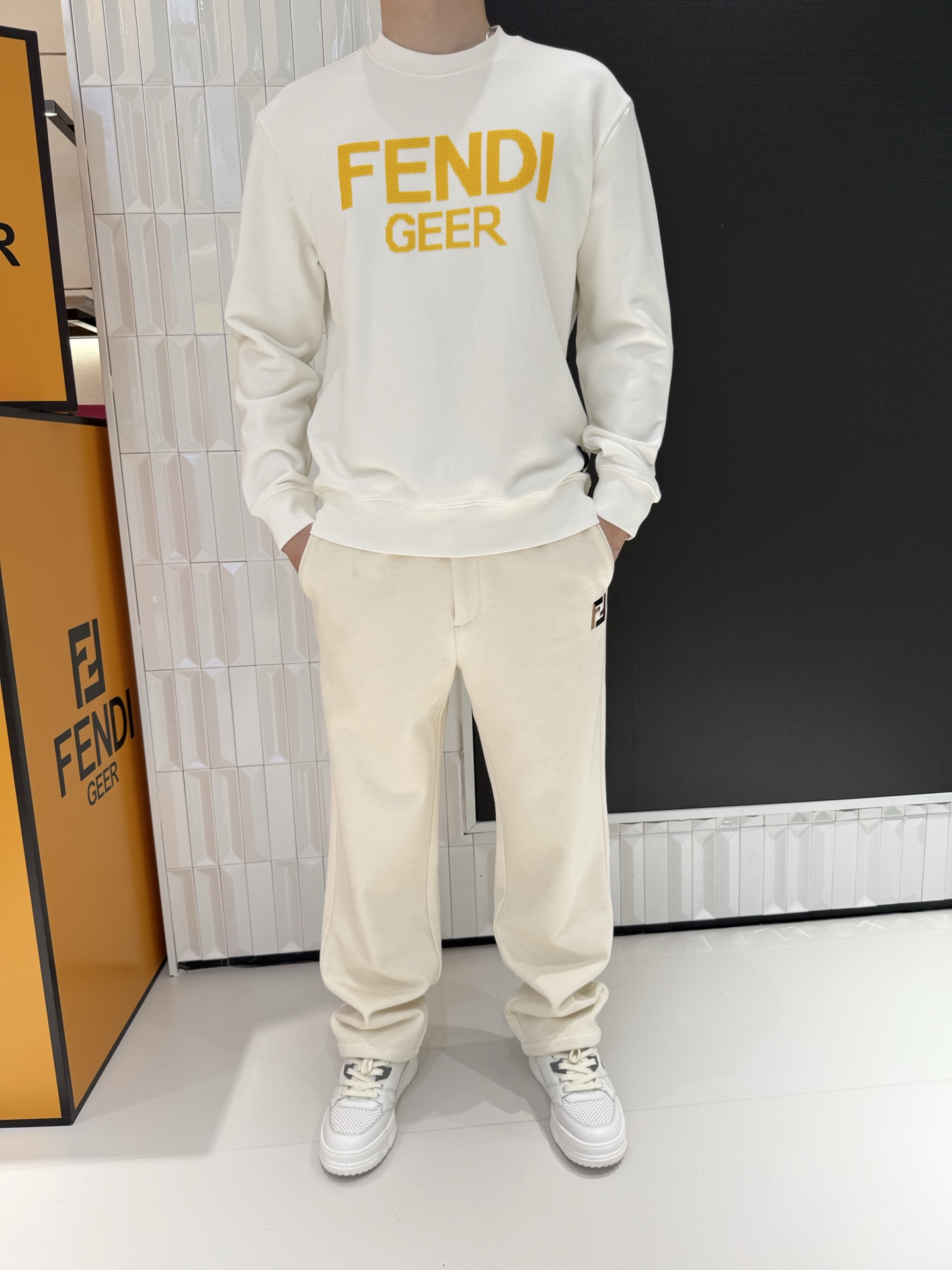NO:691213,This FENDI sweatshirt is based on classic pure white, with a dazzling yellow plaid letter print design. The white and yellow contrast creates a strong visual impact and easily becomes the focus of the look. Made of heavy-weight fabrics, it feels thick and crisp, not easy to deform, and takes into account both comfort and style. The basic round-neck version is not flattering on the body shape, and is suitable for daily wear alone or layered jackets. 'FENDI' on the chest  GEER' letters are printed with plaid texture, and the details are full of light luxury and trendy style. It is a must-have item for men to combine street style and light luxury style. Size 48-56 (model is 180cm tall and weighs 140cm, wearing size 50),, fendi, hoodie, sweatshirts, jackets & coats,19860909这款FENDI卫衣以经典纯白为基底,搭配亮眼的黄底格纹字母印花设计,白黄撞色形成强烈视觉冲击,轻松成为造型焦点.精选重磅面料打造,触感厚实挺括,不易变形,兼顾舒适度与版型质感；基础圆领版型不挑身形,日常单穿、叠穿外套都适配.胸前的“FENDI GEER”字母采用格纹纹理印花工艺,细节处尽显轻奢潮范,是男士打造街头风与轻奢风结合穿搭的必备单品. 48-56码（模特身高180体重140穿50码）,,fendi,hoodie,sweatshirts,jackets & coats,,Men's clothing