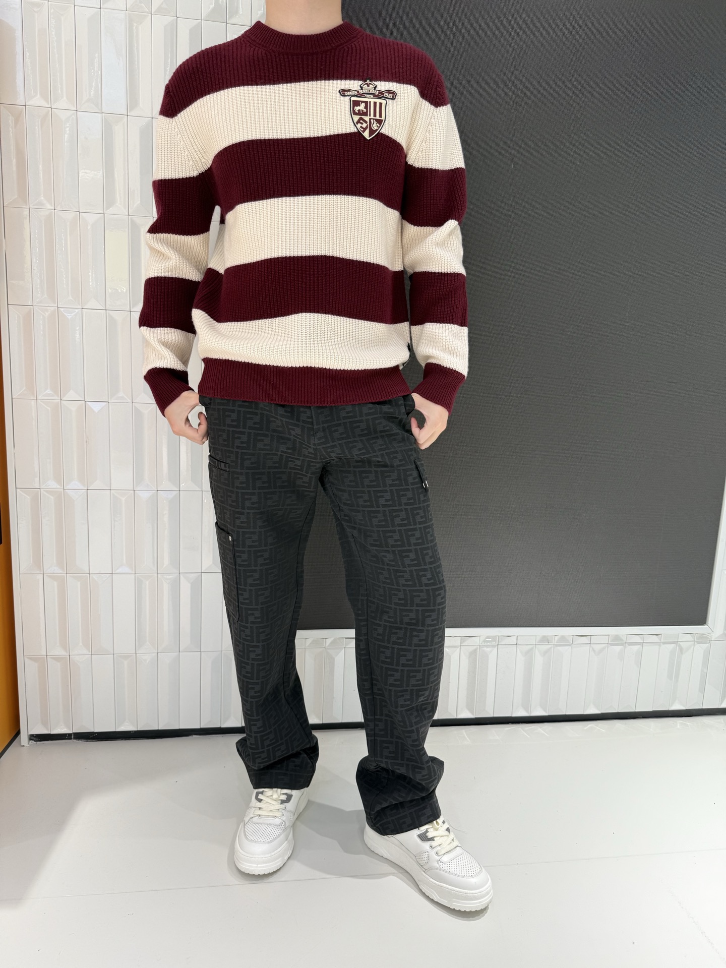 NO:703880,FENDI's contrasting striped cashmere sweater uses the classic contrasting colors of burgundy and off-white to create a visual hierarchy. The wide stripe design weakens the shortcomings of the shape, making it easy to wear with a lazy and casual atmosphere. The body is embellished with exquisite shield-shaped badge embroidery, blending retro college style with light luxury texture.  , becomes the finishing touch of the look. Woven from selected cashmere fabrics, the texture is delicate, soft and skin-friendly, with excellent warmth retention and breathability. The loose off-shoulder version is suitable for all body shapes. It can be worn alone or layered on a daily basis to create different styles. It is a versatile and light luxury item for the autumn and winter wardrobe.  Size 48-56 (model is 180cm tall and weighs 140cm, wearing size 50),, fendi, sweaters, shirts,19860909FENDI这款撞色条纹羊绒毛衣以酒红+米白经典撞色打造视觉层次,宽条纹设计弱化身形短板,轻松穿出慵懒随性的氛围感.衣身点缀精致盾形徽章刺绣,复古学院风与轻奢质感相融,成为造型的点睛之笔.精选羊绒面料织就,纹理细腻且软糯亲肤,保暖性与透气性俱佳；宽松落肩版型适配各类身形,日常单穿或叠穿衬衫都能打造不同风格,是秋冬衣橱的百搭轻奢单品 48-56码（模特身高180体重140穿50码）,,fendi,sweaters,shirts,,Men's clothing