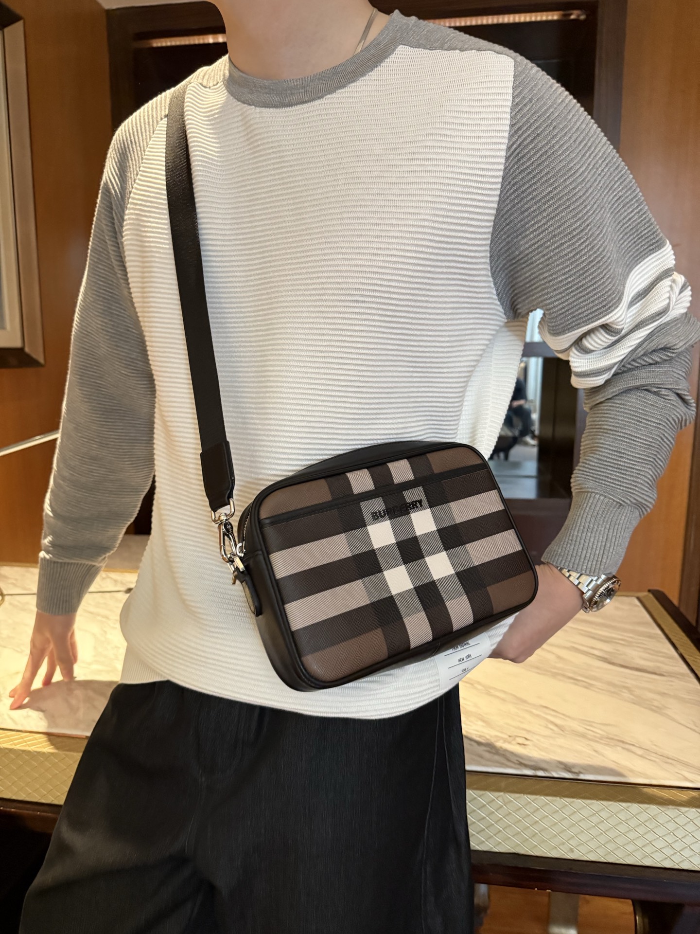 NO:731769,Burberry's plaid camera bag's iconic plaid uses Burberry's most classic smoked plaid design, which is highly recognizable and is the iconic element of the brand, with a sense of luxury. Materials and craftsmanship The bag body is made of the brand's exclusive coated canvas, which is wear-resistant and easy to care for. The edges are matched with smooth leather trimming, giving it a high-quality texture. The embossed letter logo on the front is low-key and refined.  Design and Practicality As a camera bag, its size is moderate, and the internal space is enough to accommodate daily travel necessities, such as mobile phones, wallets, keys, etc. Versatile attributes, whether it is casual T-shirts and jeans, or slightly formal shirts and trousers, it can be easily matched. The detailed design is equipped with an adjustable canvas shoulder strap, which can adjust the length according to your height and dressing style, and can be carried in various ways.,,burberry,wallets,jeans,shirts,tees,t-shirt,19860909Burberry的格纹相机包 标志性格纹采用了Burberry最经典的烟熏格纹设计,辨识度极高,是品牌的标志性元素,自带高级感. 材质与工艺包身采用了品牌专属的涂层帆布,耐磨且易于打理.边缘搭配光滑的皮革饰边,质感上乘.正面的压印字母徽标低调又精致. 设计与实用性作为一款相机包,它的尺寸适中,内部空间足够容纳日常出行的必需品,如手机、钱包、钥匙等. 百搭属性无论是休闲的T恤牛仔裤,还是稍微正式的衬衫西裤,它都能轻松搭配. 细节设计配备了一条可调节的帆布肩带,可根据身高和穿搭风格调整长度,背法多样.,,burberry,wallets,jeans,shirts,tees，t-shirt,,Men's clothing