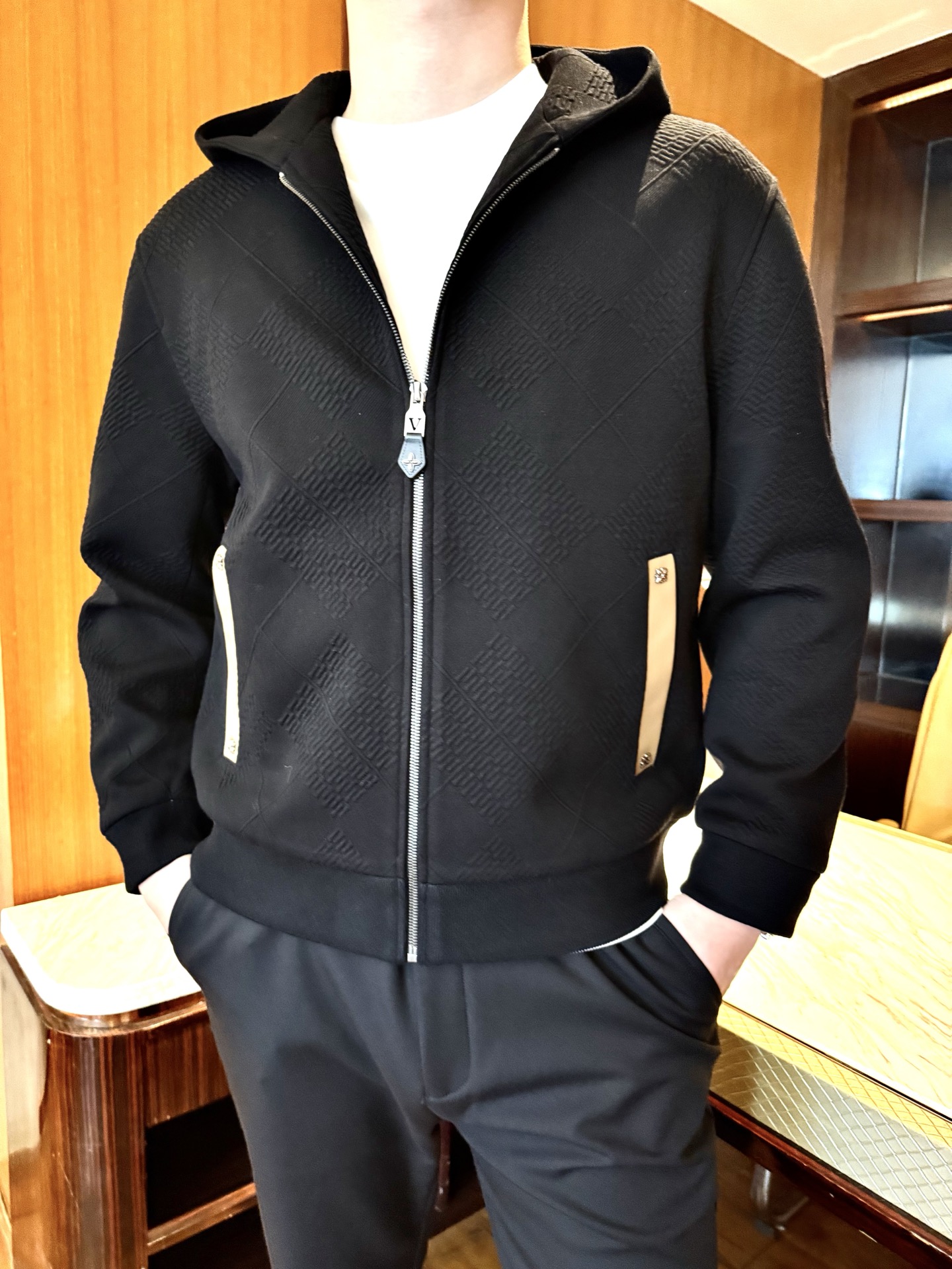 NO:731716,LV-men's black rhombus pattern hooded zipper jacket, three-dimensional rhombus jacquard fabric texture is full, bid farewell to flat monotony, soft and crisp to the touch, not easy to wrinkle, taking into account both texture and wearing comfort. The hooded zipper design is a classic casual fit, the zipper opens and closes smoothly, and the hood adds a casual atmosphere, making it easier to put on and take off in daily life. Contrast color decoration details The off-white trim strips on the pockets are matched with metal buckles to break the dullness of pure black. The light details enhance the sophistication and luxury of the outfit.  Elastic cuffs, cuffs and hem, elastic rib design, fit the body shape without being tight, windproof and have clean lines. Versatile and practical, the pure black main color is suitable for various inner wear and bottoms, and there is no pressure to switch between commuting and leisure scenes. Size 48-56 (the model is 180cm tall and weighs 140cm, wearing size 50),, louis vuitton, jackets & coats, hats,19860909LV-男士黑色菱格纹连帽拉链夹克,立体菱格提花面料纹理感拉满,告别平面单调,触感柔软且挺括不易皱,兼顾质感与穿着舒适度 连帽拉链设计经典休闲版型,拉链顺滑开合,连帽增添随性氛围,日常穿脱更便捷 撞色装饰细节口袋处米白色饰条搭配金属扣,打破纯黑沉闷,轻奢感细节提升穿搭精致度 松紧收口剪裁袖口与下摆弹性罗纹设计,贴合身形不紧绷,防风又显利落线条 百搭实穿属性纯黑主色调适配各种内搭与下装,通勤、休闲场景切换无压力.48-56码（模特设身高180体重140穿50码）,,louis vuitton,jackets & coats,hats,,Men's clothing