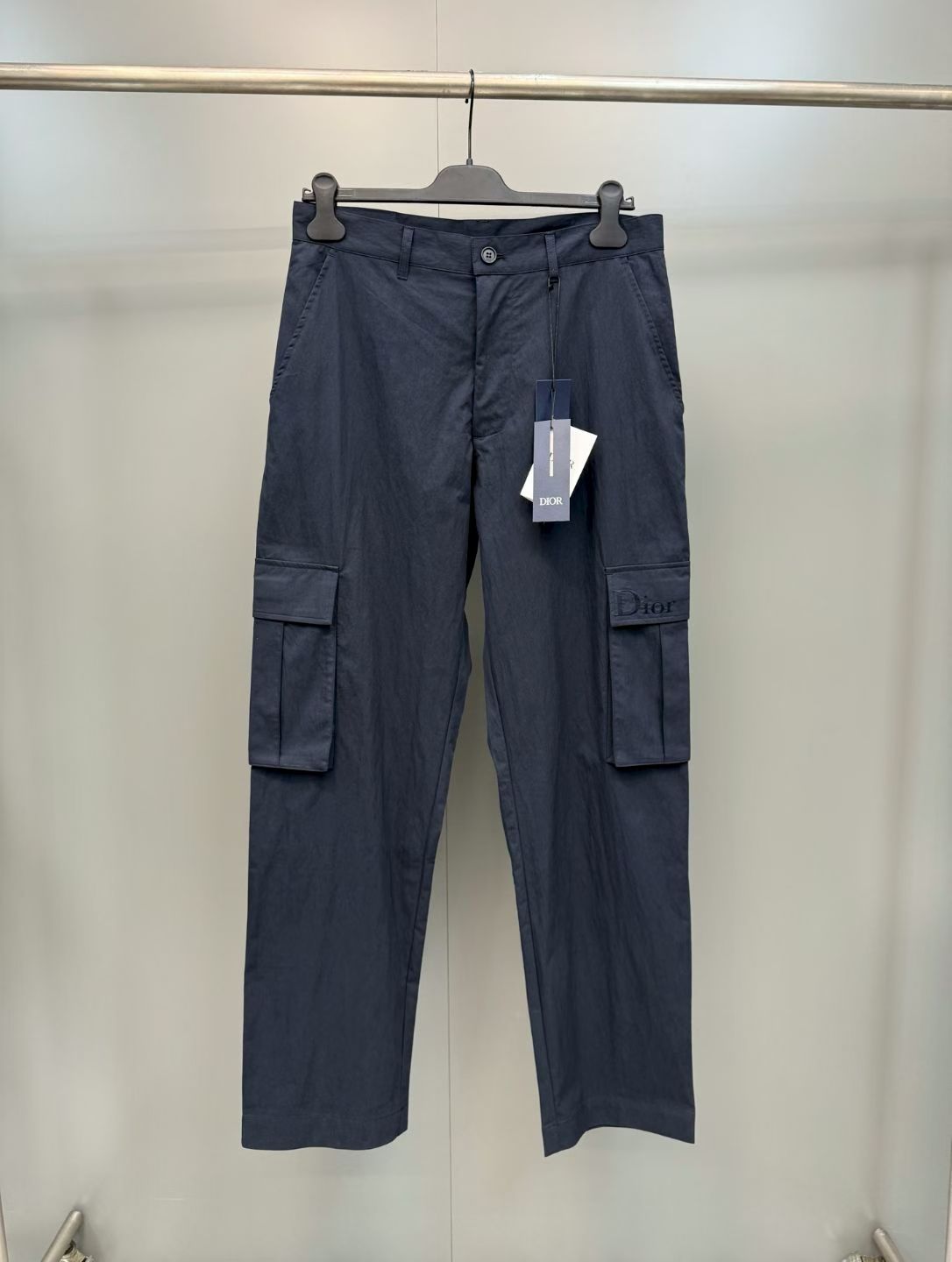 NO:852899,Dior multi-pocket cargo casual pants  Made of imported high-count combed cotton fabric, it feels crisp and wear-resistant, has excellent breathability and anti-wrinkle properties, and will not deform after long-term wear, which ensures a comfortable wearing experience; the waistband adopts a classic strap + custom-engraved button design, with invisible zipper technology, which fits the body shape and opens and closes smoothly; the pants have two sides  The side three-dimensional work pocket design combines practicality and style. The bag flap is embellished with embroidered logos, and the stitching is fine and three-dimensional, highlighting the brand recognition in a low-key manner. The loose straight version is extremely tolerant to the body shape, and the slightly cinched design of the trouser legs adapts to the needs of various scenes, taking into account work wear style and daily practicality.  Material: cotton, Dior-clothing, dior,19860909迪奥多口袋工装休闲裤 采用进口高支精梳棉面料,触感挺括耐磨,兼具出色的透气性与抗皱性,久穿不变形,奠定了单品的舒适穿着体验；腰头采用经典袢带+定制刻字纽扣设计,搭配隐形拉链工艺,贴合身形且开合顺滑；裤身两侧立体工装口袋设计,兼具实用性与造型感,袋盖处点缀刺绣标识,针法细密立体,低调中彰显品牌辨识度；宽松直筒版型对身形包容度极高,裤脚微收设计适配多场景穿搭需求,兼顾工装风格与日常实用性. 材质: 棉,迪奥-服装,dior,,Women's clothing