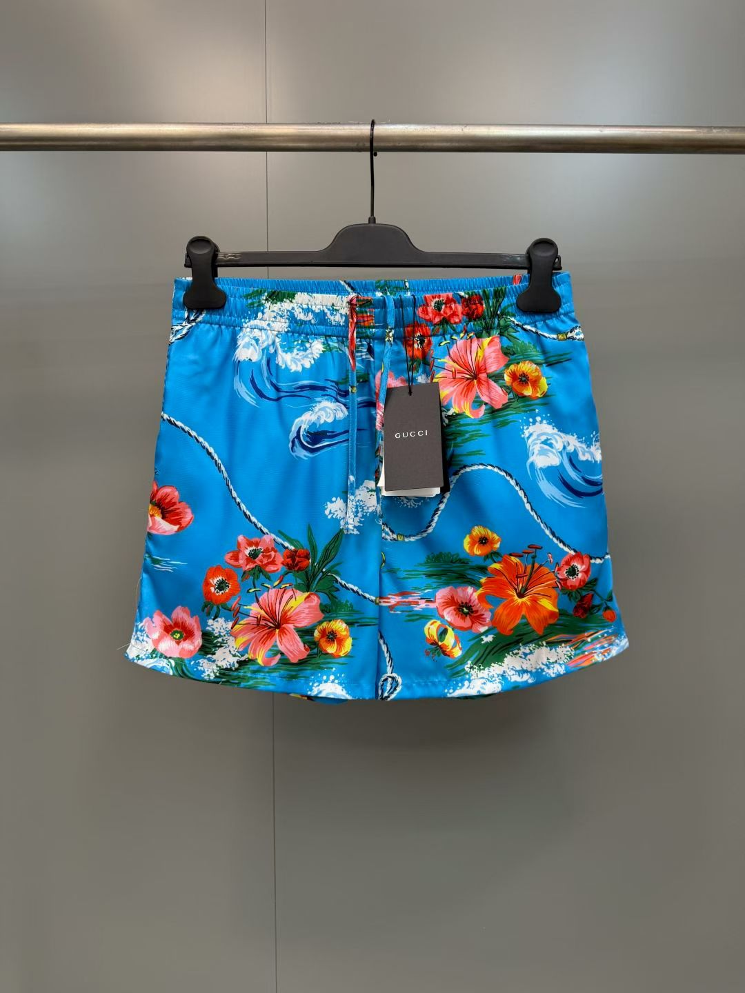 NO:857757,G's retro wave floral print casual shorts  Made of high-definition mulberry silk blended fabric, tempered by multiple pre-shrinking and sand-washing processes, the texture is silky and smooth, skin-friendly and breathable, and feels warm and luxurious to the touch. The body of the garment adopts highly active and environmentally friendly digital direct injection technology, and the retro wave flower print on the front is delicate and lifelike. The waves, flowers, ropes and brand logo elements are rich and natural in level, and the color transition is soft and not harsh, perfect.  The iconic holiday aesthetic atmosphere of the original brand, the printing has been specially fixed and will not easily crack and fall off after long-term washing; the placket uses resin buttons of the same color, with brand details engraved on the button surface, which is smooth and durable; the cuffs adopt a single-button adjustment design, the routing is smooth and neat, and the cuffs can be adjusted as needed., Gucci - Clothing, gucci, gucci, shorts,19860909G家复古海浪花卉印花休闲短裤 采用高定桑蚕丝混纺面料,经多重预缩与砂洗工艺淬炼,质地丝滑垂顺、亲肤透气,上手触感温润高级；衣身采用高活性环保数码直喷工艺,正面复古海浪花卉印花笔触细腻逼真,海浪、繁花、绳索与品牌标识元素层次丰富自然,色彩过渡柔和不生硬,完美还原品牌标志性的度假美学氛围,印花经特殊固色处理,久洗不易开裂脱落；门襟采用同色系树脂纽扣,扣面刻有品牌细节,开合顺滑耐用；袖口采用单扣调节设计,走线平整工整,可随心调整袖口松紧.,古驰-服装,gucci,gucci,shorts,,Women's clothing