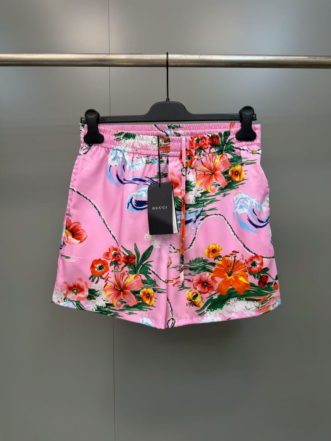 NO:857779,G's retro wave floral print casual shorts  Made of high-definition mulberry silk blended fabric, tempered by multiple pre-shrinking and sand-washing processes, the texture is silky and smooth, skin-friendly and breathable, and feels warm and luxurious to the touch. The body of the garment adopts highly active and environmentally friendly digital direct injection technology, and the retro wave flower print on the front is delicate and lifelike. The waves, flowers, ropes and brand logo elements are rich and natural in level, and the color transition is soft and not harsh, perfect.  The iconic holiday aesthetic atmosphere of the original brand, the printing has been specially fixed and will not easily crack and fall off after long-term washing; the placket uses resin buttons of the same color, with brand details engraved on the button surface, which is smooth and durable; the cuffs adopt a single-button adjustment design, the routing is smooth and neat, and the cuffs can be adjusted as needed., Gucci - Clothing, gucci, gucci, shorts,19860909G家复古海浪花卉印花休闲短裤 采用高定桑蚕丝混纺面料,经多重预缩与砂洗工艺淬炼,质地丝滑垂顺、亲肤透气,上手触感温润高级；衣身采用高活性环保数码直喷工艺,正面复古海浪花卉印花笔触细腻逼真,海浪、繁花、绳索与品牌标识元素层次丰富自然,色彩过渡柔和不生硬,完美还原品牌标志性的度假美学氛围,印花经特殊固色处理,久洗不易开裂脱落；门襟采用同色系树脂纽扣,扣面刻有品牌细节,开合顺滑耐用；袖口采用单扣调节设计,走线平整工整,可随心调整袖口松紧.,古驰-服装,gucci,gucci,shorts,,Women's clothing