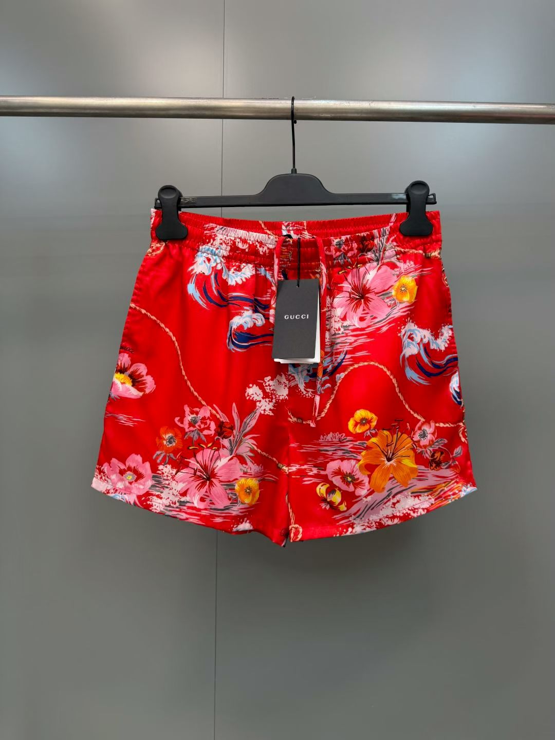 NO:857803,G's retro wave floral print casual shorts  Made of high-definition mulberry silk blended fabric, tempered by multiple pre-shrinking and sand-washing processes, the texture is silky and smooth, skin-friendly and breathable, and feels warm and luxurious to the touch. The body of the garment adopts highly active and environmentally friendly digital direct injection technology, and the retro wave flower print on the front is delicate and lifelike. The waves, flowers, ropes and brand logo elements are rich and natural in level, and the color transition is soft and not harsh, perfect.  The iconic holiday aesthetic atmosphere of the original brand, the printing has been specially fixed and will not easily crack and fall off after long-term washing; the placket uses resin buttons of the same color, with brand details engraved on the button surface, which is smooth and durable; the cuffs adopt a single-button adjustment design, the routing is smooth and neat, and the cuffs can be adjusted as needed., Gucci - Clothing, gucci, gucci, shorts,19860909G家复古海浪花卉印花休闲短裤 采用高定桑蚕丝混纺面料,经多重预缩与砂洗工艺淬炼,质地丝滑垂顺、亲肤透气,上手触感温润高级；衣身采用高活性环保数码直喷工艺,正面复古海浪花卉印花笔触细腻逼真,海浪、繁花、绳索与品牌标识元素层次丰富自然,色彩过渡柔和不生硬,完美还原品牌标志性的度假美学氛围,印花经特殊固色处理,久洗不易开裂脱落；门襟采用同色系树脂纽扣,扣面刻有品牌细节,开合顺滑耐用；袖口采用单扣调节设计,走线平整工整,可随心调整袖口松紧.,古驰-服装,gucci,gucci,shorts,,Women's clothing