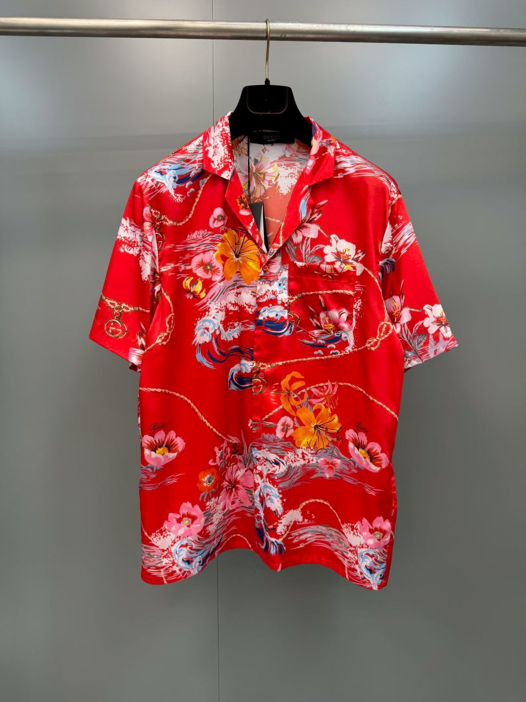 NO:857813,G's retro wave floral print casual short-sleeved shirt  It is made of high-definition mulberry silk blended fabric, tempered by multiple pre-shrinking and sand-washing processes. The texture is silky and smooth, skin-friendly and breathable, and feels warm and luxurious to the touch. The body of the garment is made of high-activity environmentally friendly digital direct-injection technology. The retro wave floral print on the front is delicate and lifelike. The waves, flowers, ropes and brand logo elements are rich and natural, and the color transition is soft and not harsh, perfectly restoring the brand logo.  Ideal holiday aesthetic atmosphere, the printing has been specially fixed and will not easily crack and fall off after long-term washing; the placket uses resin buttons of the same color, with brand details engraved on the button surface, which is smooth and durable; the cuffs adopt a single-button adjustment design, the routing is smooth and neat, and the cuffs can be adjusted at will., Gucci - Clothing, gucci, gucci, shirts, T-shirt,19860909G家复古海浪花卉印花休闲短袖衬衫 采用高定桑蚕丝混纺面料,经多重预缩与砂洗工艺淬炼,质地丝滑垂顺、亲肤透气,上手触感温润高级；衣身采用高活性环保数码直喷工艺,正面复古海浪花卉印花笔触细腻逼真,海浪、繁花、绳索与品牌标识元素层次丰富自然,色彩过渡柔和不生硬,完美还原品牌标志性的度假美学氛围,印花经特殊固色处理,久洗不易开裂脱落；门襟采用同色系树脂纽扣,扣面刻有品牌细节,开合顺滑耐用；袖口采用单扣调节设计,走线平整工整,可随心调整袖口松紧.,古驰-服装,gucci,gucci,shirts,T-shirt,,Women's clothing
