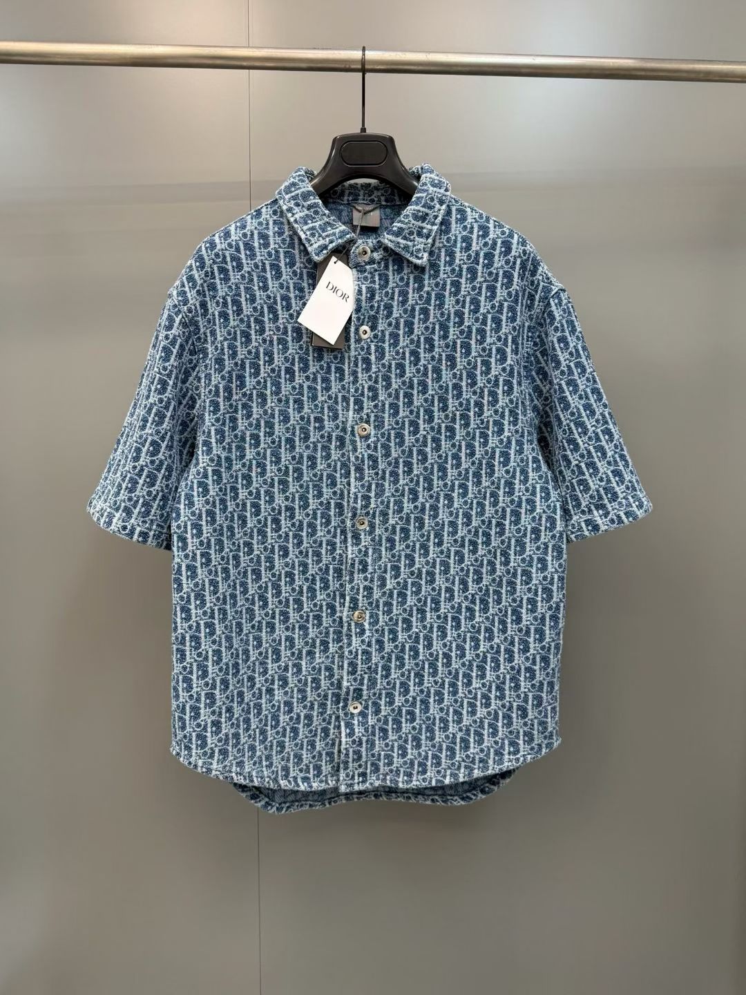 NO:857756,D's full-print presbyopia denim short-sleeved shirt  The brand's exclusive custom-made heavy denim fabric has been treated with multiple rounds of washing, distressing and softening. The fabric feels crisp and stylish, with the matte texture of retro denim. The body is fully printed with classic presbyopia patterns. It uses high-precision denim reactive jacquard technology. The texture is distinct, the color transition is natural and delicate, and the pattern edges are clear and sharp. It can be worn and washed for a long time.  It is not easy to fade and crack, which fundamentally ensures the brand recognition and long-term durability of the single product. The overall shape is a classic loose short-sleeved shirt cut, paired with straight shorts of the same series. After multiple rounds of ergonomic data optimization, it takes into account the neat and straight street style and the slimming effect of modifying the body shape. It can easily cover the shortcomings of the body and also  It can create an effortless sense of luxury. The classic lapel design is paired with the brand's customized metal button placket to create a high-end texture with a minimalist design language. Luxurious details are hidden in the low-key, which perfectly interprets the brand's century-old classic aesthetics and deeply integrates retro denim style with modern wear texture. The collar and placket adopt reinforced locking technology.  It is not easy to loosen and deform after long-term wear, and it can maintain the stiffness of the pattern even after repeated wear; the classic denim blue color is versatile and does not matter the style. Wear it as a set to create a complete trendy look, and wear it separately to unlock a variety of matching possibilities., Dior-clothing, dior, dior, shorts, shirts, T-shirt,19860909D家满印老花牛仔短袖衬衫 采用品牌专属定制重磅牛仔面料,经过多轮水洗做旧与柔化工艺处理,面料触感挺括有型,自带复古牛仔的哑光肌理,衣身满印经典老花图案,采用高精度牛仔活性提花工艺,纹理凹凸分明,色彩过渡自然细腻,图案边缘清晰锐利,久穿久洗不易掉色开裂,从根源上保证了单品的品牌辨识度与长期穿着的耐用性；整体版型为经典宽松短袖衬衫剪裁,搭配同系列直筒短裤,经过多轮人体工学数据优化,兼顾了利落挺括的街头风格与修饰身形的显瘦效果,既能轻松遮盖身形短板,又能打造不费力的高奢穿搭感；经典翻领设计搭配品牌定制金属纽扣门襟,以极简的设计语言打造高级质感,低调中暗藏奢华细节,完美诠释了品牌百年传承的经典美学,将复古牛仔风与现代穿搭质感深度融合；领口与门襟采用加固锁边工艺,久穿不易松垮变形,反复穿着也能保持版型的挺括度；经典牛仔蓝配色百搭不挑穿搭风格,成套穿着打造完整潮流造型,拆分穿着也能解锁多种搭配可能.,迪奥-服装,dior,dior,shorts,shirts,T-shirt,,Women's clothing