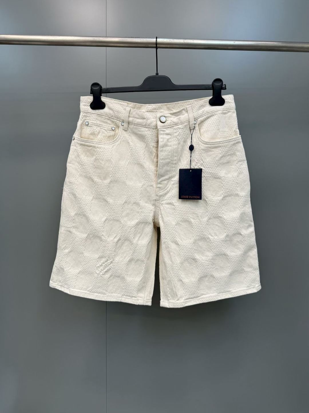 NO:857721,1V 26ss Checkered Denim Shorts in Off-White 3D Damier Jacquard featuring Pharrell Williams  A brand-new silhouette launched in the 2026 spring and summer show. Yarn-dyed jacquard denim refers to a kind of denim made using the yarn-dyed jacquard process, which is a twill weave and indigo-dyed denim. This kind of fabric is directly woven into various patterns and patterns during the weaving process through the yarn-dyed jacquard process, making the surface of the denim show a richer texture and visual effect.  Sand washing of finished pieces is a post-processing process for jeans, which will have a certain fading effect and stale feeling after washing. During the sand washing process, the clothes will be rubbed with pumice or sand in a special sand washing machine to produce a uniform layer of plush on the surface of the fabric, giving the jeans a polished, Louis Vuitton-clothing, louis vuitton, shorts, jeans,198609091V 26ss 方格牛仔短裤米白 3D Damier 提花面料,展现 Pharrell Williams 于2026春夏秀场推出的崭新廓形.色织提花丹宁是指一种采用色织提花工艺制作的牛仔布,也就是斜纹织法的、靛蓝染色的粗斜纹布.这种布料通过色织提花工艺,在织布过程中直接织入各种花纹和图案,使得牛仔布表面呈现出更加丰富的纹理和视觉效果. 成件砂洗是一种牛仔裤的后处理工艺,在洗后具有一定的褪色效果和陈旧感.砂洗过程中,衣物会与浮石或专用砂洗机中的砂粒进行摩使织物表面产生一层均匀的毛绒,赋予牛仔擦,路易威登-服装,louis vuitton,shorts,jeans,,Women's clothing