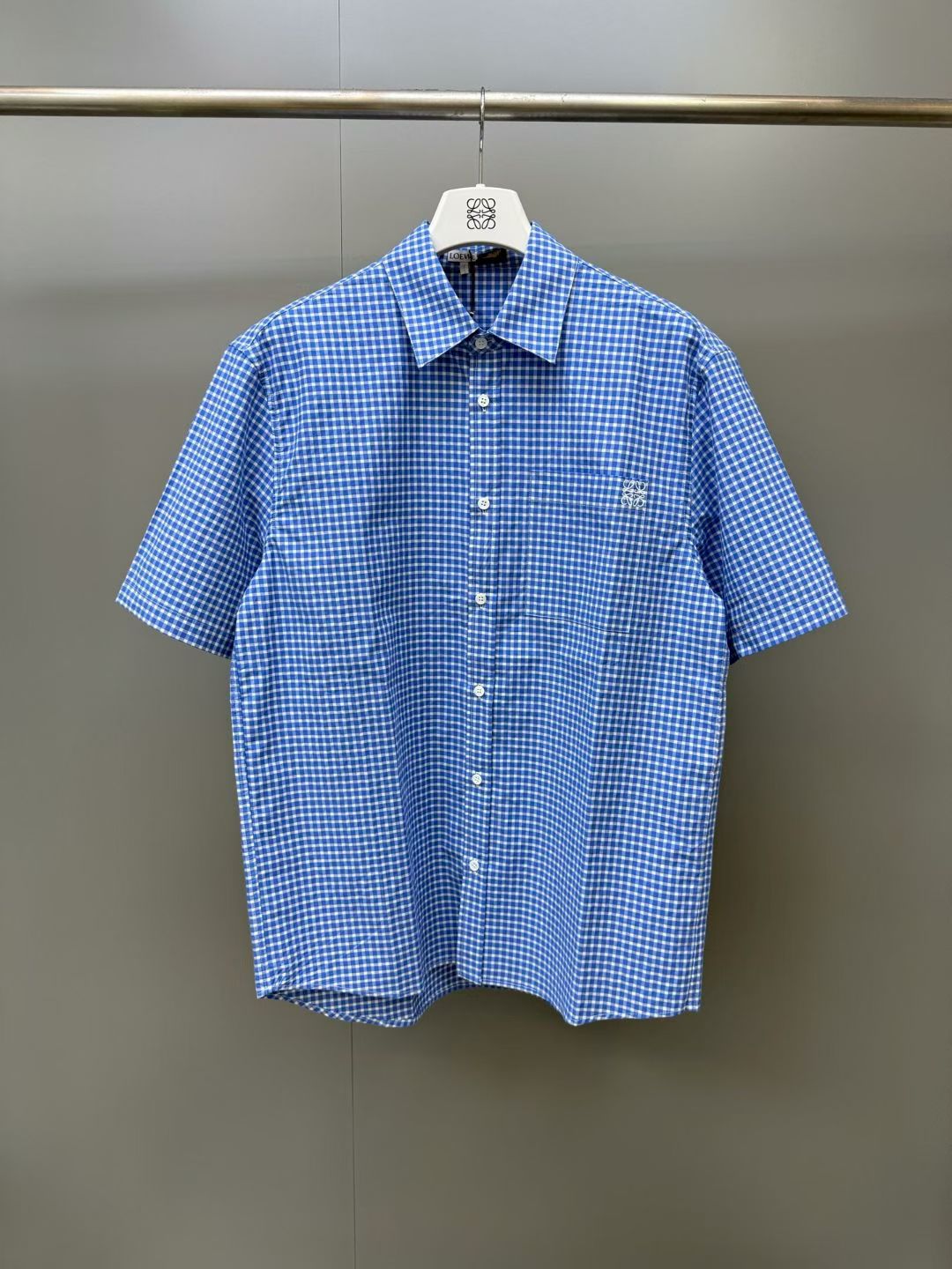 NO:892650,LOE pocket embroidery contrasting plaid lapel short-sleeved shirt. The front and rear panels of the body, left and right short sleeves, whole placket buttons, chest pockets, collar splicing, and all positions of the hem are completely symmetrical. The embroidery points on the chest must also accurately adhere to the plaid pattern. The overlay of multiple processes is a hard-core manifestation of counter-level quality. People who understand the details of fabrics can tell the grade at a glance. Loewe-clothing, loewe, loewe, shirts, T-shirt,19860909LOE口袋刺绣撞色格纹翻领短袖衬衫 衣身前后片、左右短袖、门襟整条排扣、胸前口袋、领口拼接、下摆所有位置格纹横竖线条完全贯通对称,胸口刺绣点位也要精准贴合格纹,多重工艺叠加是专柜级品质硬核体现,懂面料细节的人一眼就能看出档次,罗意威-服装,loewe,loewe,shirts,T-shirt,,Women's clothing