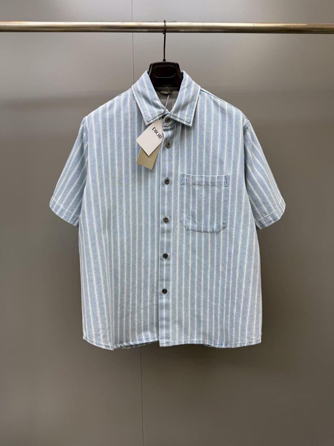 NO:931919,CD26 new coat shirt decorated with classic patterns. It is carefully made of blue striped cotton twill fabric. It has horn button closure and Dior embroidery above the chest patch pocket, which is unique. It can be worn with buttons or left open and layered with a T-shirt to add personality to the casual look., Dior - Clothing, dior, dior, jackets & coats, shirts,19860909CD26新款外套衬衫 饰以经典图案 采用蓝色条纹棉质斜纹面料精心制作,牛角扣开合,胸前贴袋上方饰以 Dior 刺绣,别具一格.可系上纽扣穿着或敞开与 T 恤叠搭,为休闲造型增添个性风范.,迪奥-服装,dior,dior,jackets & coats,shirts,,Women's clothing