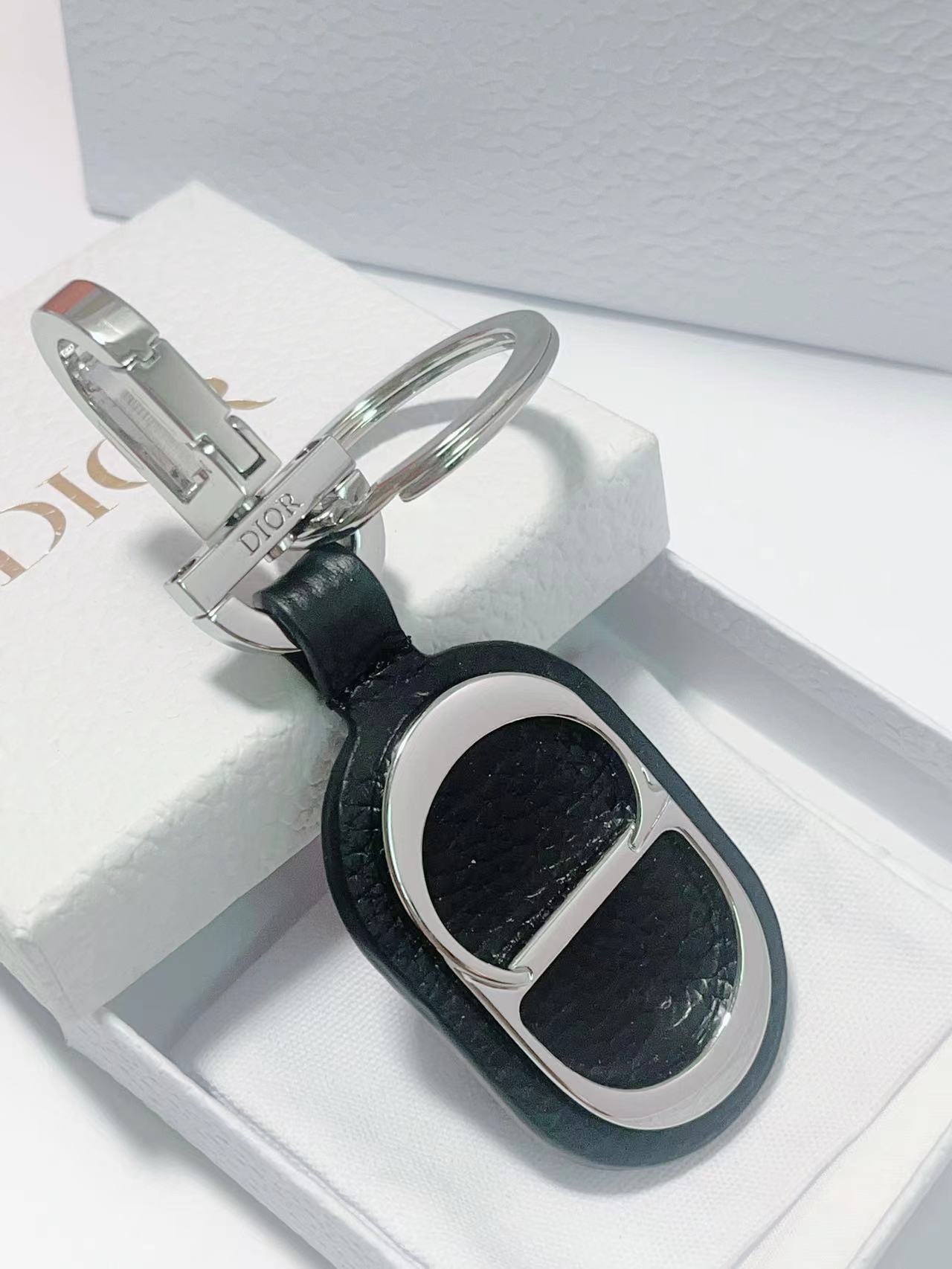 “CD Diamond Logo Key Button with Leather and Brass Details for Accessories” - 图片 6