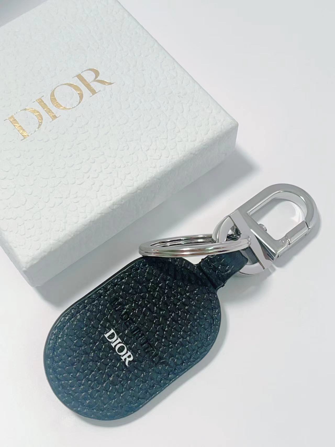 “CD Diamond Logo Key Button with Leather and Brass Details for Accessories” - 图片 4