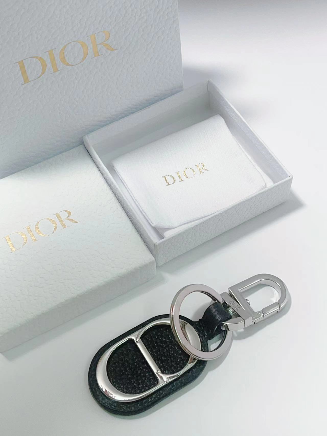 “CD Diamond Logo Key Button with Leather and Brass Details for Accessories” - 图片 3