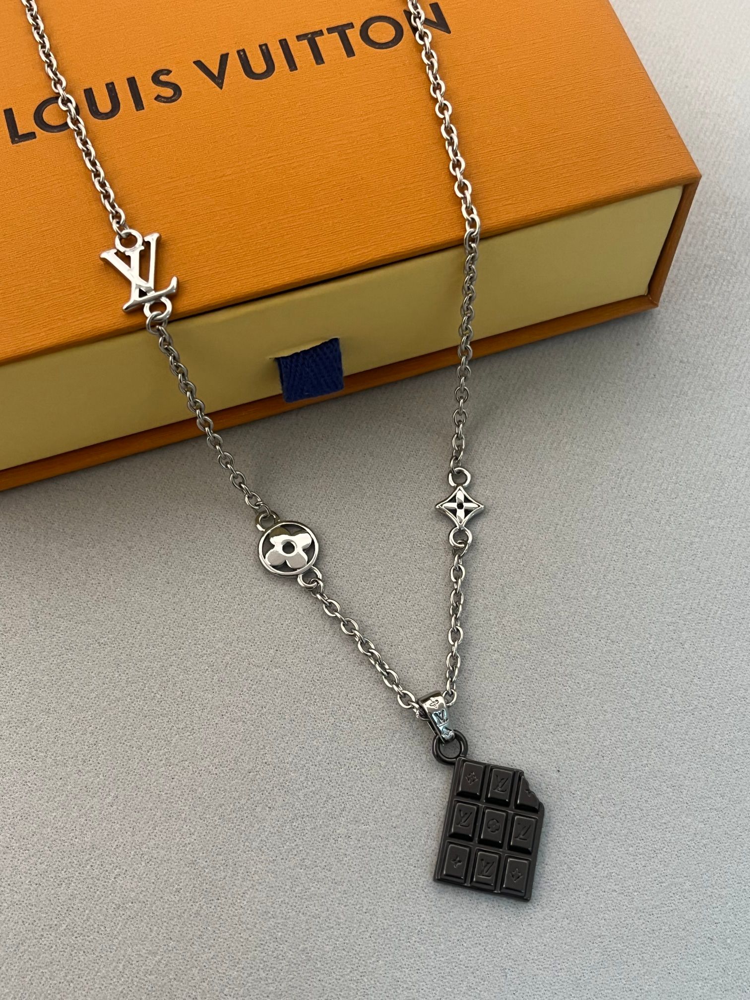❤️105包邮/原单代购级别
LV Chocolate Bar坠饰为不同方格镂刻LV字母和 Monogram 花卉，以边角的不规则缺口释放灵动趣意。无论搭配LVYours 项链或其他坠饰，均可彰显个性风采。
商品货号M02567	