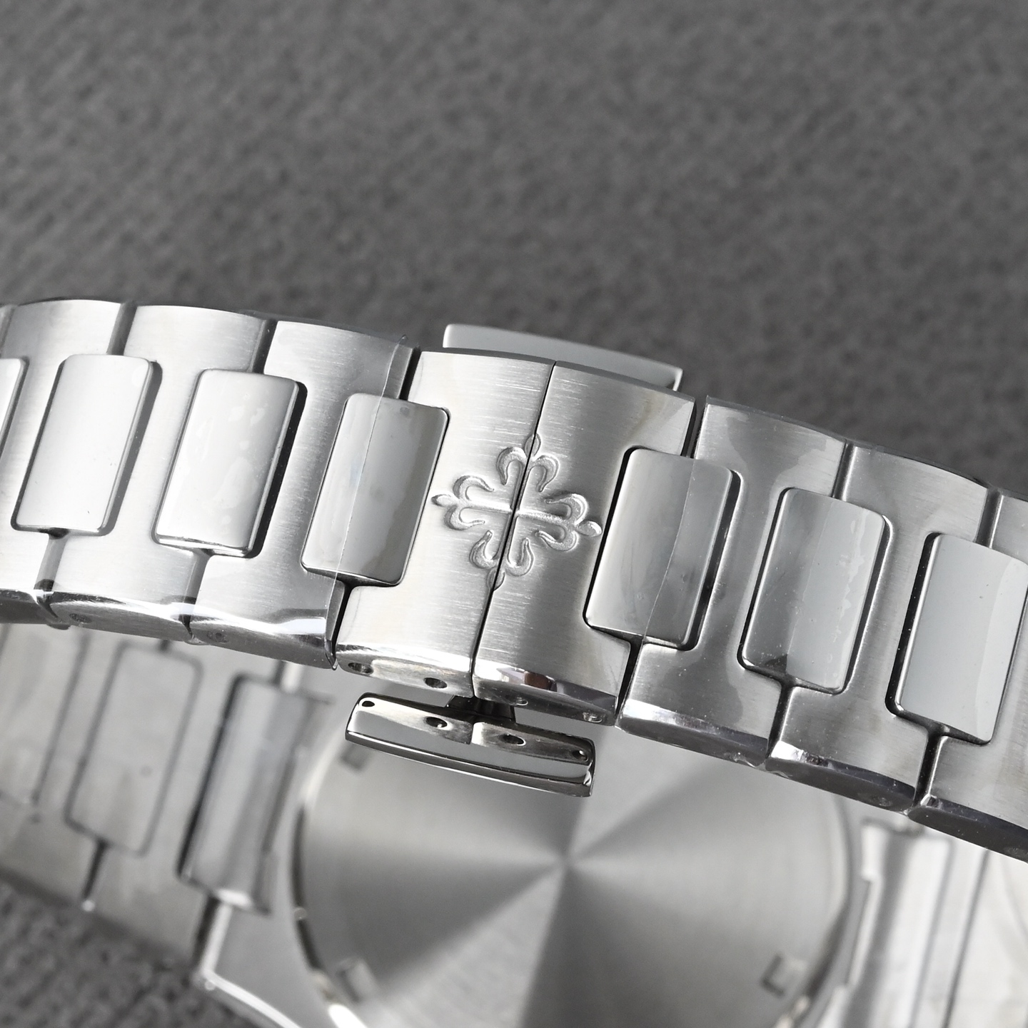 NO:393375,The strap consists of multiple independent links, each link is milled with precision CNC to ensure smooth and loose connections. The polishing process of the strap is extremely complex and requires many steps to complete. Mechanical sandblasting is used to initially remove metal burrs. Corundum velvet polishing is polished on the cast iron plate in a '8-shaped' track to form a delicate matte effect. Satin matte matte is used to use a special grinding wheel to make the link surface appear uniform velvet texture. Mirror polishing The central link is hand-mirror polished to make it have a high reflective effect in light. Manual assembly Each link needs to be individually aligned, assembled and welded to ensure overall flexibility. Pin fixing is made of stainless steel or precious metal pins to ensure that it will not loosen when used for a long time. After wearing for a long time, the flexibility between the links can still be maintained, and deformation caused by metal fatigue will not occur.19860909表带由多个独立链节组成,每个链节均经过精密CNC铣削,确保连接顺滑无松动.表带的抛光工艺极为复杂,需要很多步骤完成.机械喷砂用于初步去除金属毛刺.金刚砂起绒抛光 在铸铁盘上以'8字形'轨迹打磨,形成细腻的哑光效果.缎面磨砂 采用特殊磨砂轮,使链节表面呈现均匀的丝绒质感.镜面抛光 中央链节采用手工镜面抛光,使其在光线下呈现高反光效果.手工组装 每个链节需单独对齐、装配并焊接,确保整体柔韧度.销钉固定 采用精钢或贵金属销钉,确保长期使用不会松动,长期佩戴后,仍能保持链节间的灵活度,不会出现金属疲劳导致的变形.,,Watch