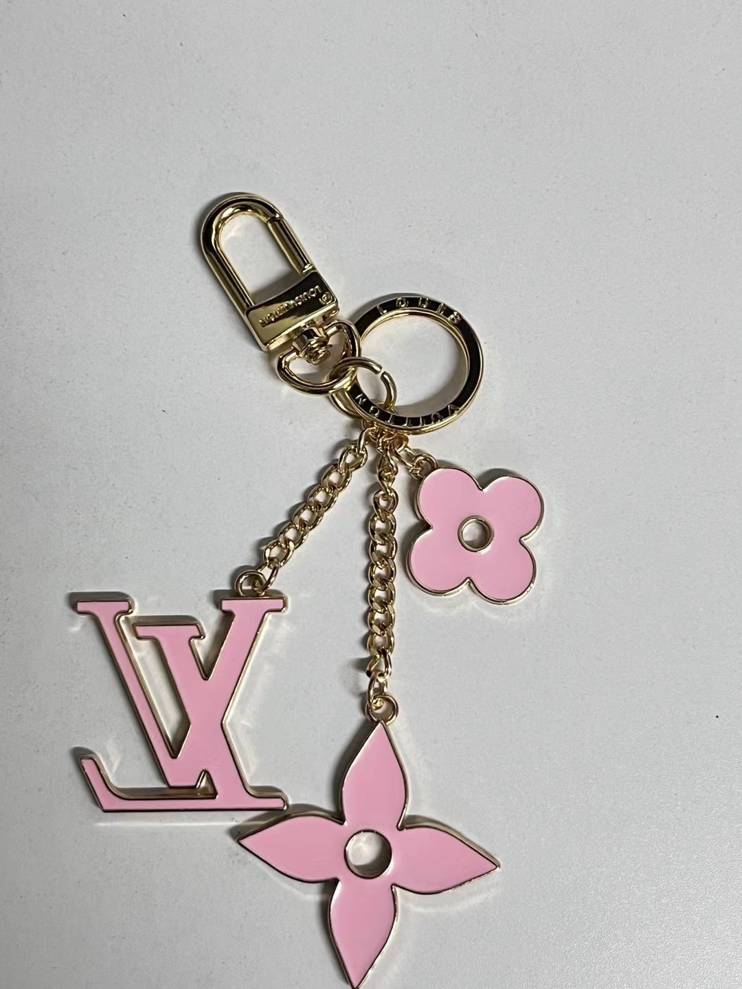 Metal flower keychain at different angles.