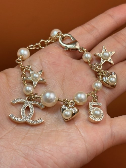 Bracelet Chanel avec Perles, Étoiles et Charmes Iconiques - Élégance et Féminité 1 Bracelet Chanel avec Perles, Étoiles et Charmes Iconiques - Élégance et Féminité
