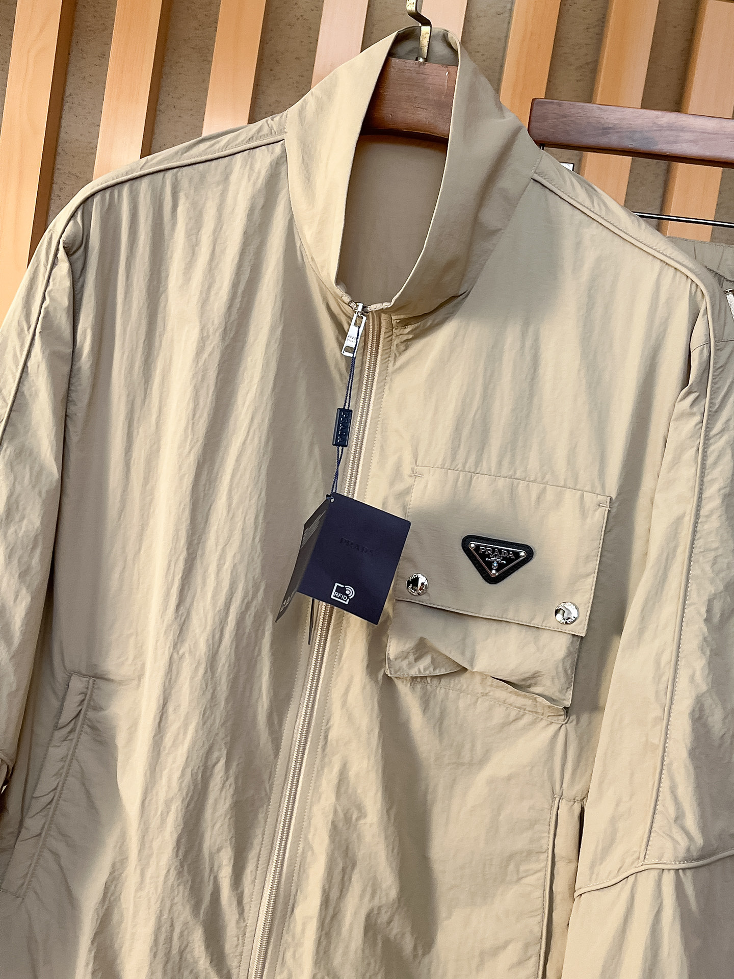 套装普拉达 上新🈺25ss早春运动套装尼龙风衣➕卫裤 现货秒发本款运动衫为轻盈科技面料全幅压印图案，注入