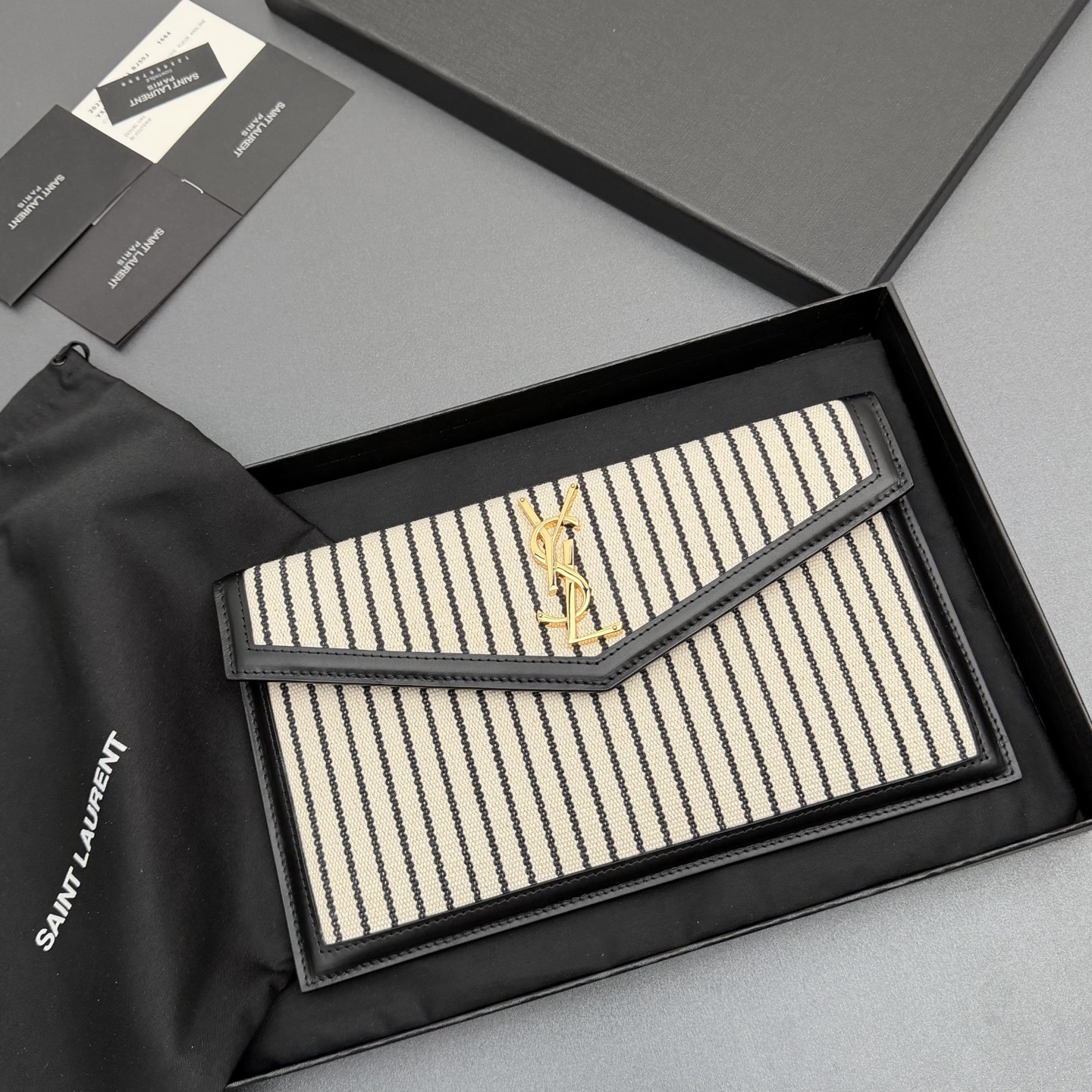 P370【特级五金原厂皮】UPTOWN 帆布拼皮革手拿包
小号信封手拿包，翻盖饰以金属字母标志
帆布/牛皮
金色金属配件
磁扣开合设计
内部一个主隔层
编号: 565739   黑白条/金扣
尺寸:w27 xh16 xd2cm