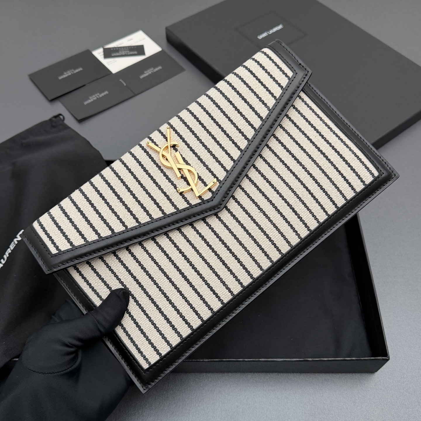 P370【特级五金原厂皮】UPTOWN 帆布拼皮革手拿包
小号信封手拿包，翻盖饰以金属字母标志
帆布/牛皮
金色金属配件
磁扣开合设计
内部一个主隔层
编号: 565739   黑白条/金扣
尺寸:w27 xh16 xd2cm