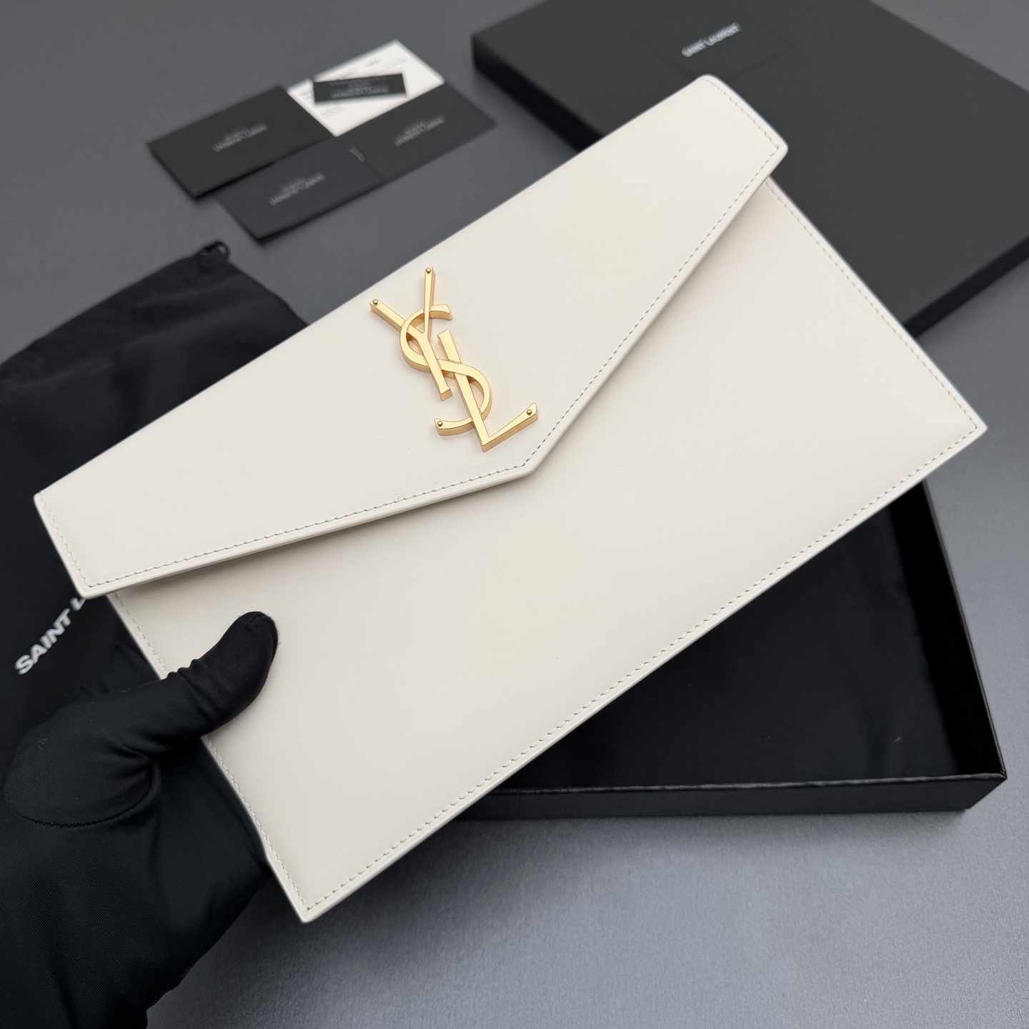 P370【特级五金原厂皮】UPTOWN光滑皮革手拿包
小号信封手拿包，翻盖饰以金属字母标志
牛皮
金色金属配件
磁扣开合设计
内部一个主隔层
编号: 565739   白色平纹/金扣
尺寸:w27 xh16 xd2cm