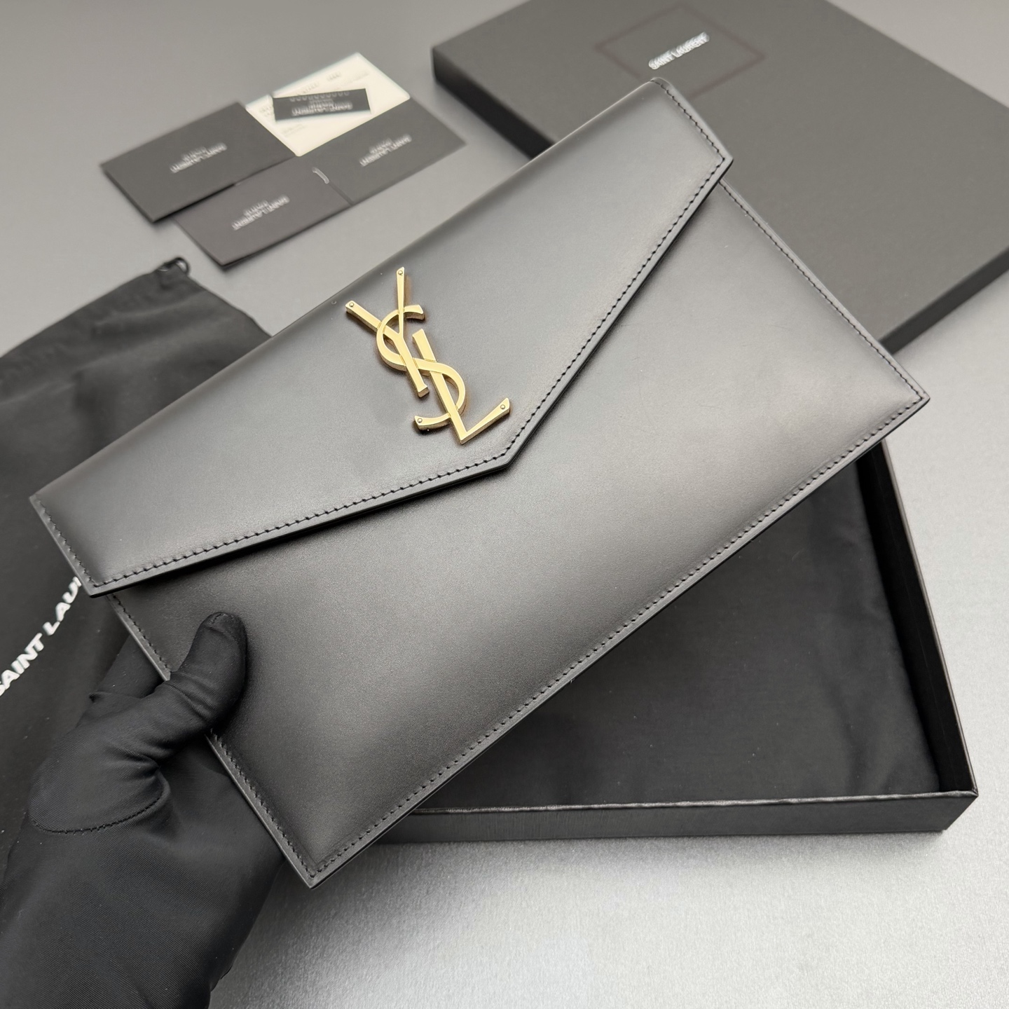 P370【特级五金原厂皮】UPTOWN光滑皮革手拿包
小号信封手拿包，翻盖饰以金属字母标志
牛皮
金色金属配件
磁扣开合设计
内部一个主隔层
编号: 565739   黑色平纹/金扣
尺寸:w27 xh16 xd2cm