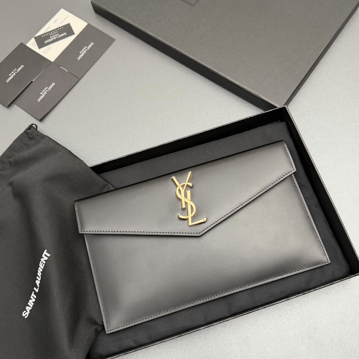 P370【特级五金原厂皮】UPTOWN光滑皮革手拿包
小号信封手拿包，翻盖饰以金属字母标志
牛皮
金色金属配件
磁扣开合设计
内部一个主隔层
编号: 565739   黑色平纹/金扣
尺寸:w27 xh16 xd2cm