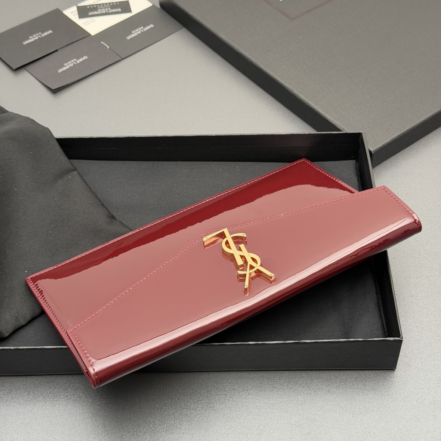 p350。【特级五金原厂皮】 UPTOWN漆皮皮革手拿包
小号信封手拿包，翻盖饰以金属字母标志
牛皮
金色金属配件
磁扣开合设计
内部一个主隔层
编号: 565739   枣红漆皮/金扣
尺寸:w27 xh16 xd2cm