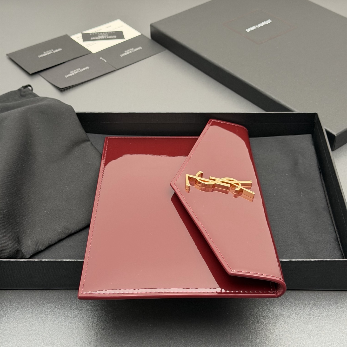 p350。【特级五金原厂皮】 UPTOWN漆皮皮革手拿包
小号信封手拿包，翻盖饰以金属字母标志
牛皮
金色金属配件
磁扣开合设计
内部一个主隔层
编号: 565739   枣红漆皮/金扣
尺寸:w27 xh16 xd2cm