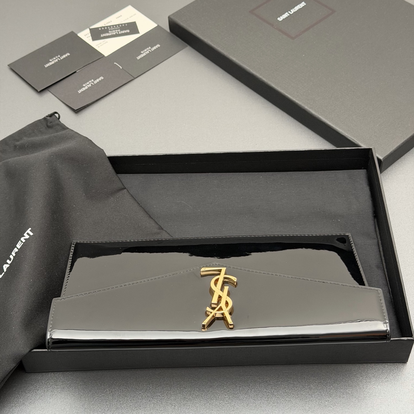 p350。【特级五金原厂皮】 UPTOWN漆皮皮革手拿包
小号信封手拿包，翻盖饰以金属字母标志
牛皮
金色金属配件
磁扣开合设计
内部一个主隔层
编号: 565739   黑色漆皮/金扣
尺寸:w27 xh16 xd2cm