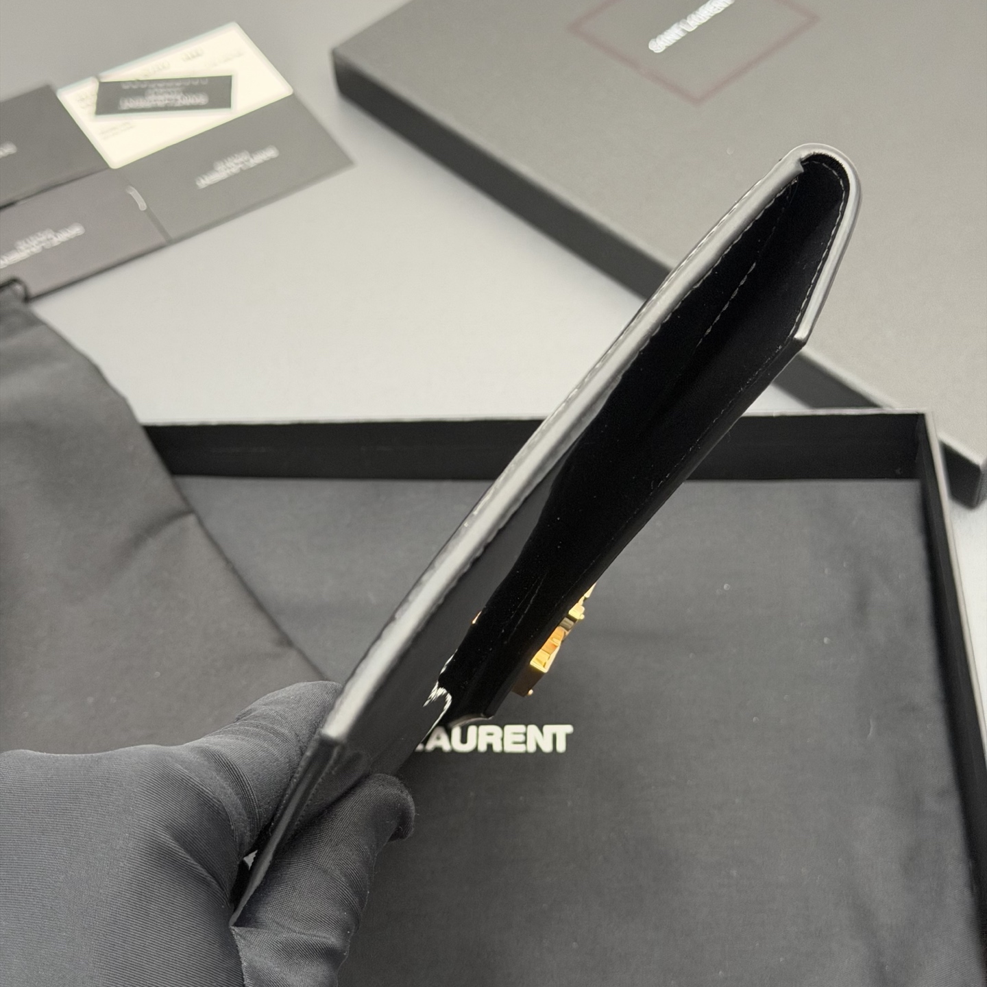 p350。【特级五金原厂皮】 UPTOWN漆皮皮革手拿包
小号信封手拿包，翻盖饰以金属字母标志
牛皮
金色金属配件
磁扣开合设计
内部一个主隔层
编号: 565739   黑色漆皮/金扣
尺寸:w27 xh16 xd2cm