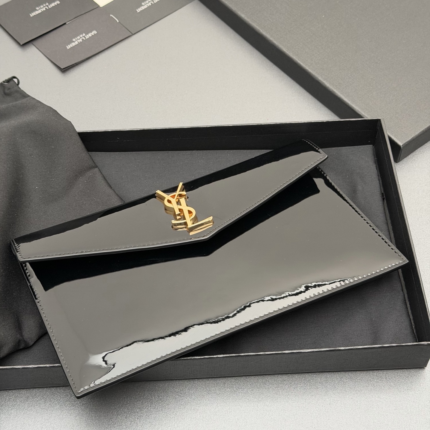 p350。【特级五金原厂皮】 UPTOWN漆皮皮革手拿包
小号信封手拿包，翻盖饰以金属字母标志
牛皮
金色金属配件
磁扣开合设计
内部一个主隔层
编号: 565739   黑色漆皮/金扣
尺寸:w27 xh16 xd2cm