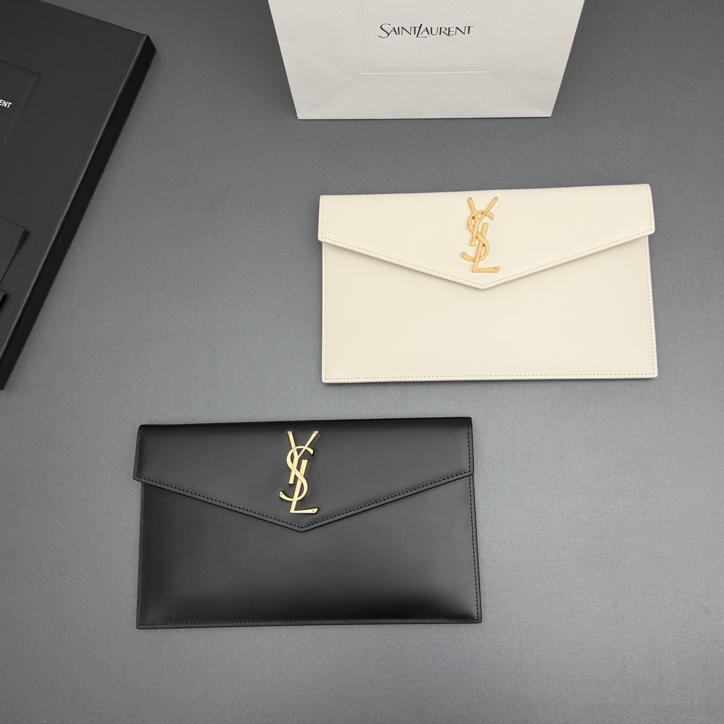 【特级五金原厂皮】 UPTOWN皮革手拿包
小号信封手拿包，翻盖饰以金属字母标志
牛皮
金色金属配件
磁扣开合设计
内部一个主隔层
编号: 565739   
尺寸:w27 xh16 xd2cm