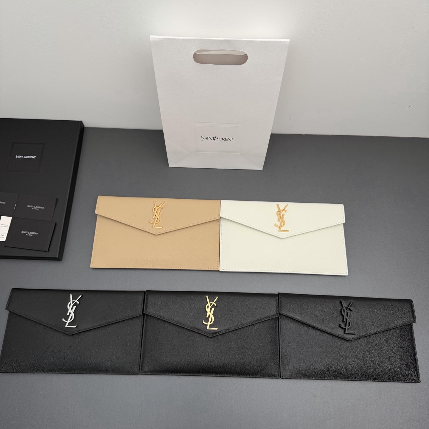 【特级五金原厂皮】 UPTOWN皮革手拿包
小号信封手拿包，翻盖饰以金属字母标志
牛皮
金色金属配件
磁扣开合设计
内部一个主隔层
编号: 565739   
尺寸:w27 xh16 xd2cm