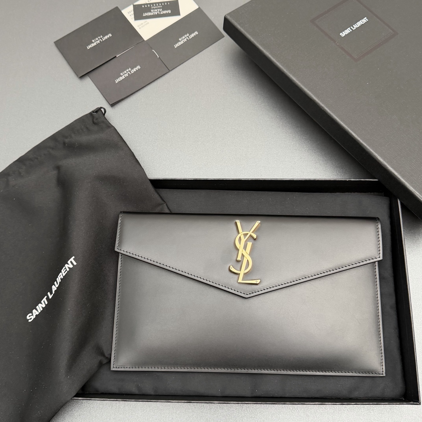 【特级五金原厂皮】 UPTOWN皮革手拿包
小号信封手拿包，翻盖饰以金属字母标志
牛皮
金色金属配件
磁扣开合设计
内部一个主隔层
编号: 565739   
尺寸:w27 xh16 xd2cm