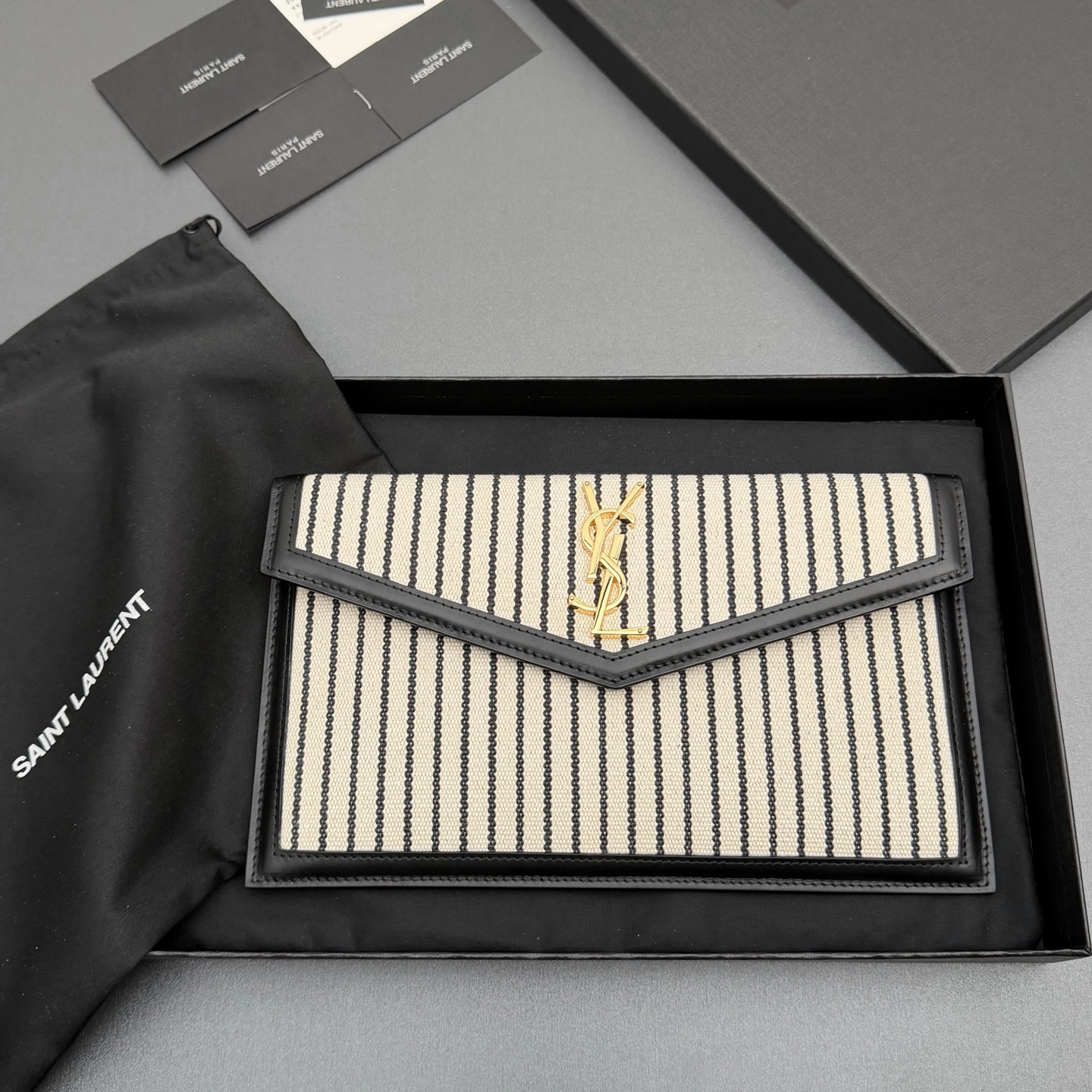 【特级五金原厂皮】 UPTOWN皮革手拿包
小号信封手拿包，翻盖饰以金属字母标志
牛皮
金色金属配件
磁扣开合设计
内部一个主隔层
编号: 565739   
尺寸:w27 xh16 xd2cm