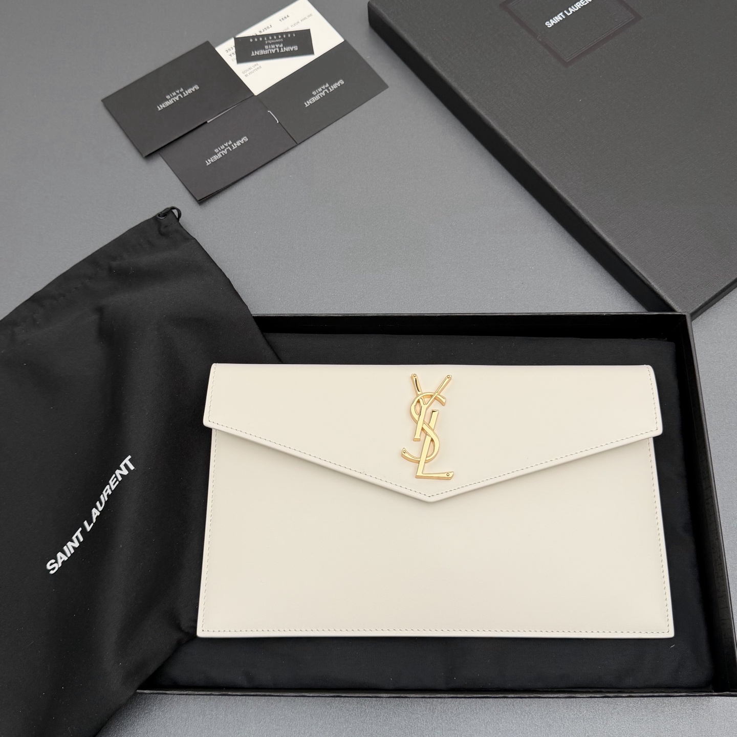 【特级五金原厂皮】 UPTOWN皮革手拿包
小号信封手拿包，翻盖饰以金属字母标志
牛皮
金色金属配件
磁扣开合设计
内部一个主隔层
编号: 565739   
尺寸:w27 xh16 xd2cm