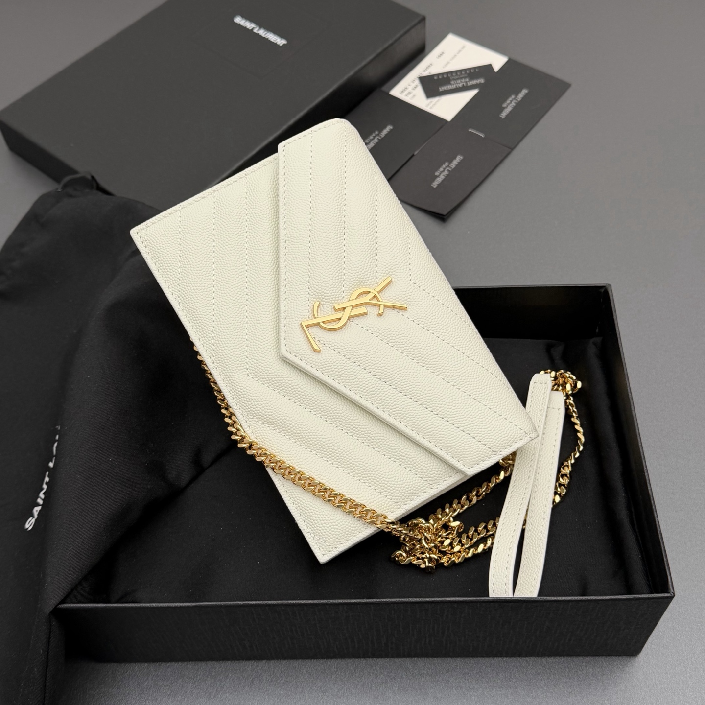 P470【特级五金原厂皮】ENVELOPE粒面皮革链条钱包
隽永链条钱包，标志性V形绗缝明缝线。实用性强，设有一个拉链口袋和多个卡槽。搭配皮革加固链接肩带，可肩背或斜挎携着。
牛皮
金色黄铜金属配件
按扣开合
六个卡槽
一个内部拉链口袋
编号: 393953 白色球纹/金扣
尺寸:w19xh12.5xd4cm