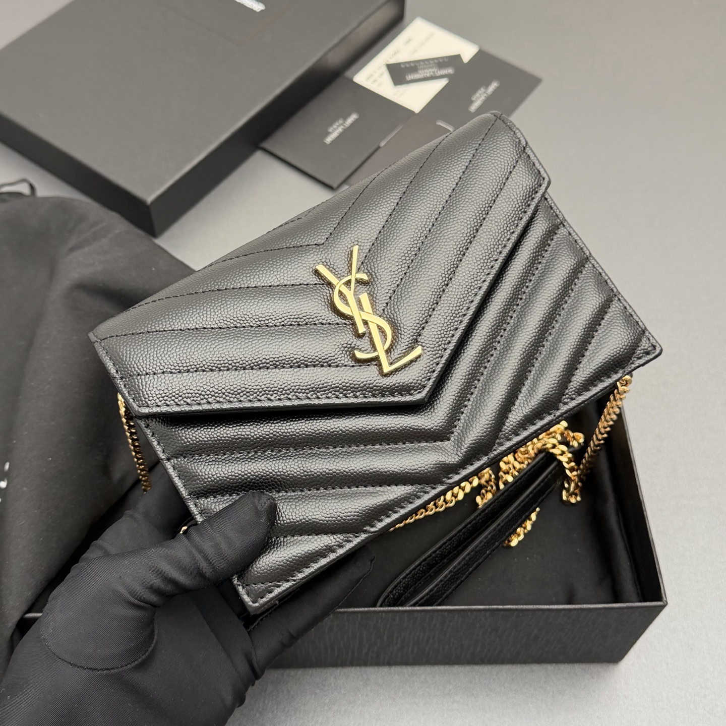 P470【特级五金原厂皮】ENVELOPE粒面皮革链条钱包
隽永链条钱包，标志性V形绗缝明缝线。实用性强，设有一个拉链口袋和多个卡槽。搭配皮革加固链接肩带，可肩背或斜挎携着。
牛皮
金色黄铜金属配件
按扣开合
六个卡槽
一个内部拉链口袋
编号: 393953 黑色球纹/金扣
尺寸:w19xh12.5xd4cm