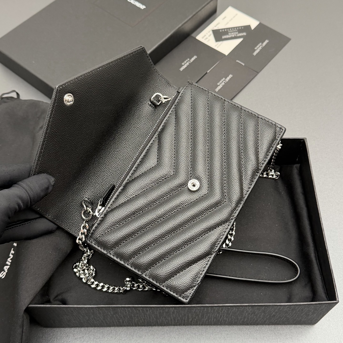 P470【特级五金原厂皮】ENVELOPE粒面皮革链条钱包
隽永链条钱包，标志性V形绗缝明缝线。实用性强，设有一个拉链口袋和多个卡槽。搭配皮革加固链接肩带，可肩背或斜挎携着。
牛皮
银色黄铜金属配件
按扣开合
六个卡槽
一个内部拉链口袋
编号: 393953 黑色球纹/银扣
尺寸:w19xh12.5xd4cm