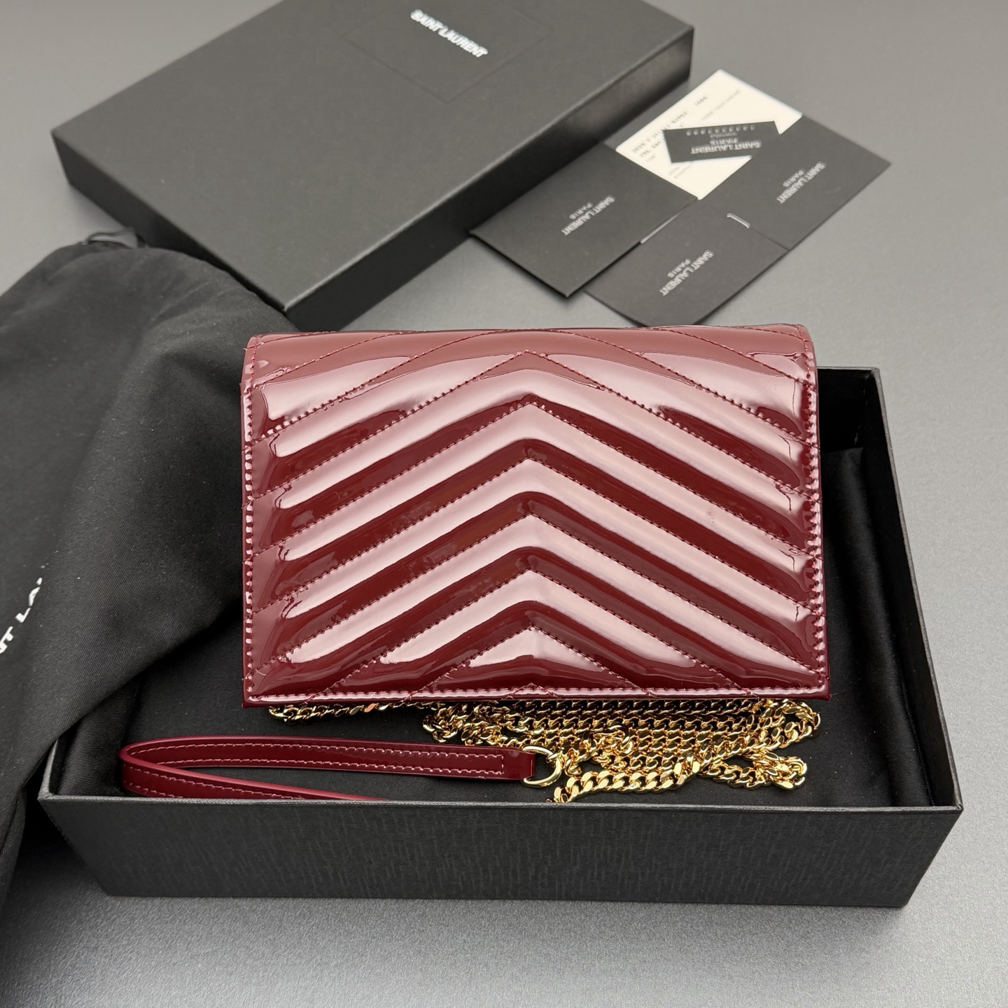 P470【特级五金原厂皮】ENVELOPE漆皮亮面皮革链条钱包
隽永链条钱包，标志性V形绗缝明缝线。实用性强，设有一个拉链口袋和多个卡槽。搭配皮革加固链接肩带，可肩背或斜挎携着。
牛皮
黑枪色黄铜金属配件
按扣开合
六个卡槽
一个内部拉链口袋
编号: 393953 酒红漆皮/金扣
尺寸:w19xh12.5xd4cm