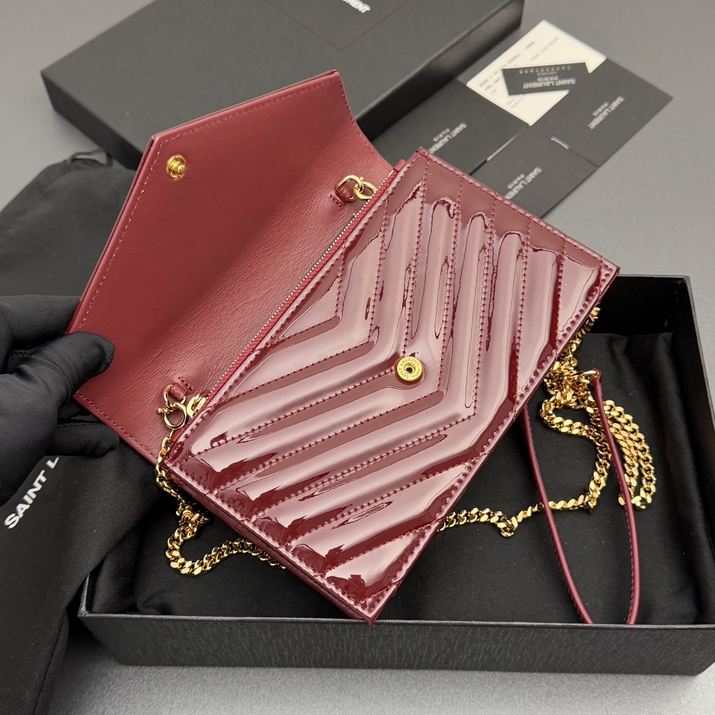 P470【特级五金原厂皮】ENVELOPE漆皮亮面皮革链条钱包
隽永链条钱包，标志性V形绗缝明缝线。实用性强，设有一个拉链口袋和多个卡槽。搭配皮革加固链接肩带，可肩背或斜挎携着。
牛皮
黑枪色黄铜金属配件
按扣开合
六个卡槽
一个内部拉链口袋
编号: 393953 酒红漆皮/金扣
尺寸:w19xh12.5xd4cm