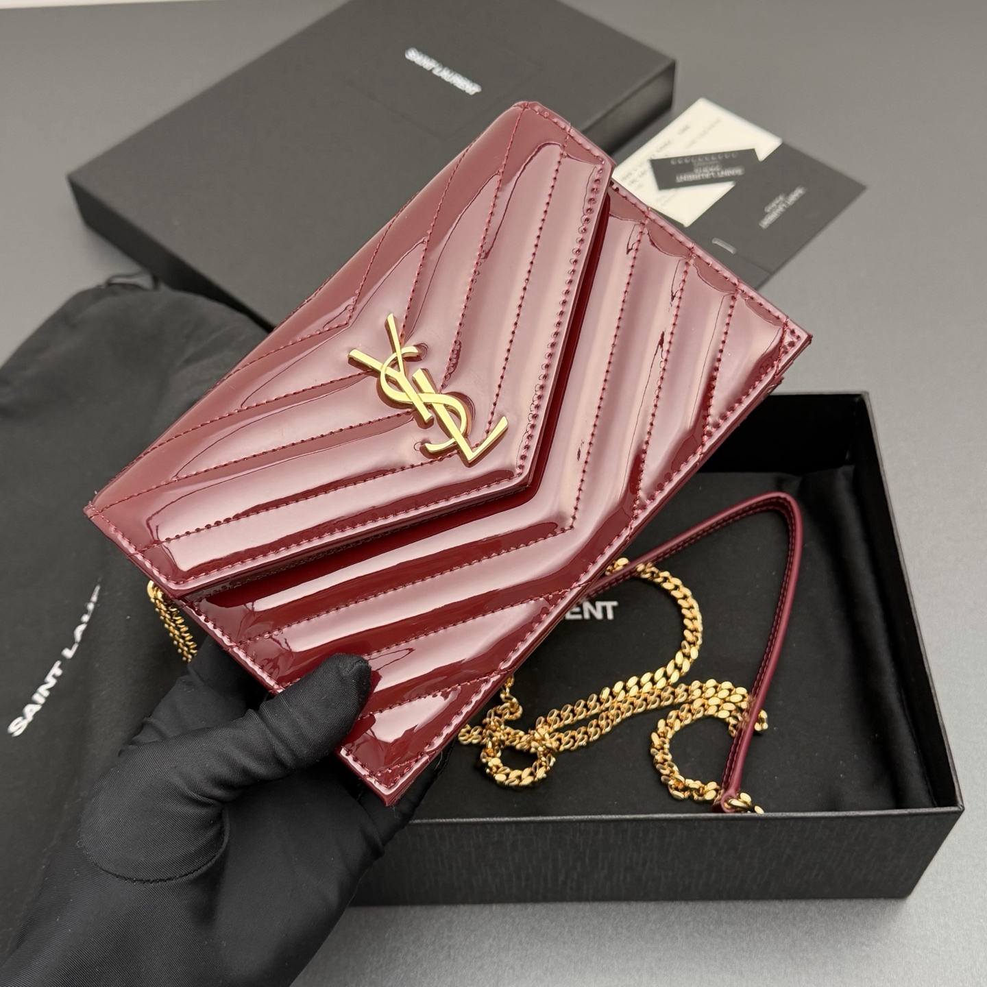 P470【特级五金原厂皮】ENVELOPE漆皮亮面皮革链条钱包
隽永链条钱包，标志性V形绗缝明缝线。实用性强，设有一个拉链口袋和多个卡槽。搭配皮革加固链接肩带，可肩背或斜挎携着。
牛皮
黑枪色黄铜金属配件
按扣开合
六个卡槽
一个内部拉链口袋
编号: 393953 酒红漆皮/金扣
尺寸:w19xh12.5xd4cm