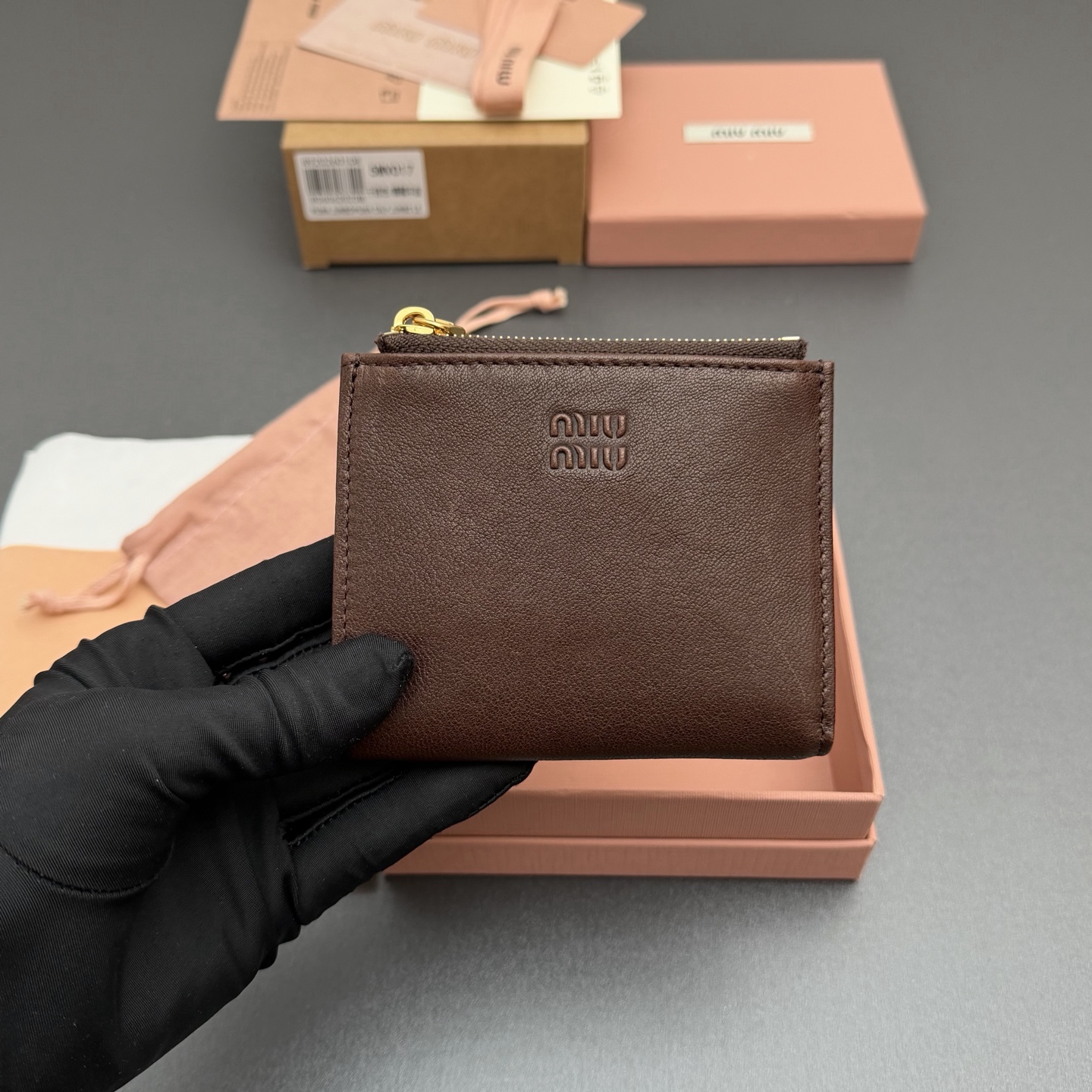 p285。【特级五金进口原厂皮】  复古羊皮革短款钱包
经典与复古细节融合于这款皮革钱包，正面饰有标志，尽显品牌格调，$宽敞的内部空间伴有卡槽和隔层，彰显功能性。
按扣开合
刻字徽标
一个钞票隔层
六个卡槽
两个内部口袋
两个拉链式零钱袋带衬里
编号:5MV017  石南木/植鞣羊皮
尺寸:宽度11厘米x高度9.2厘米