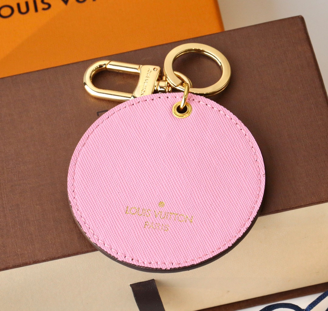 Angle view of the coffee-colored round Cherry Blossom cat keychain.